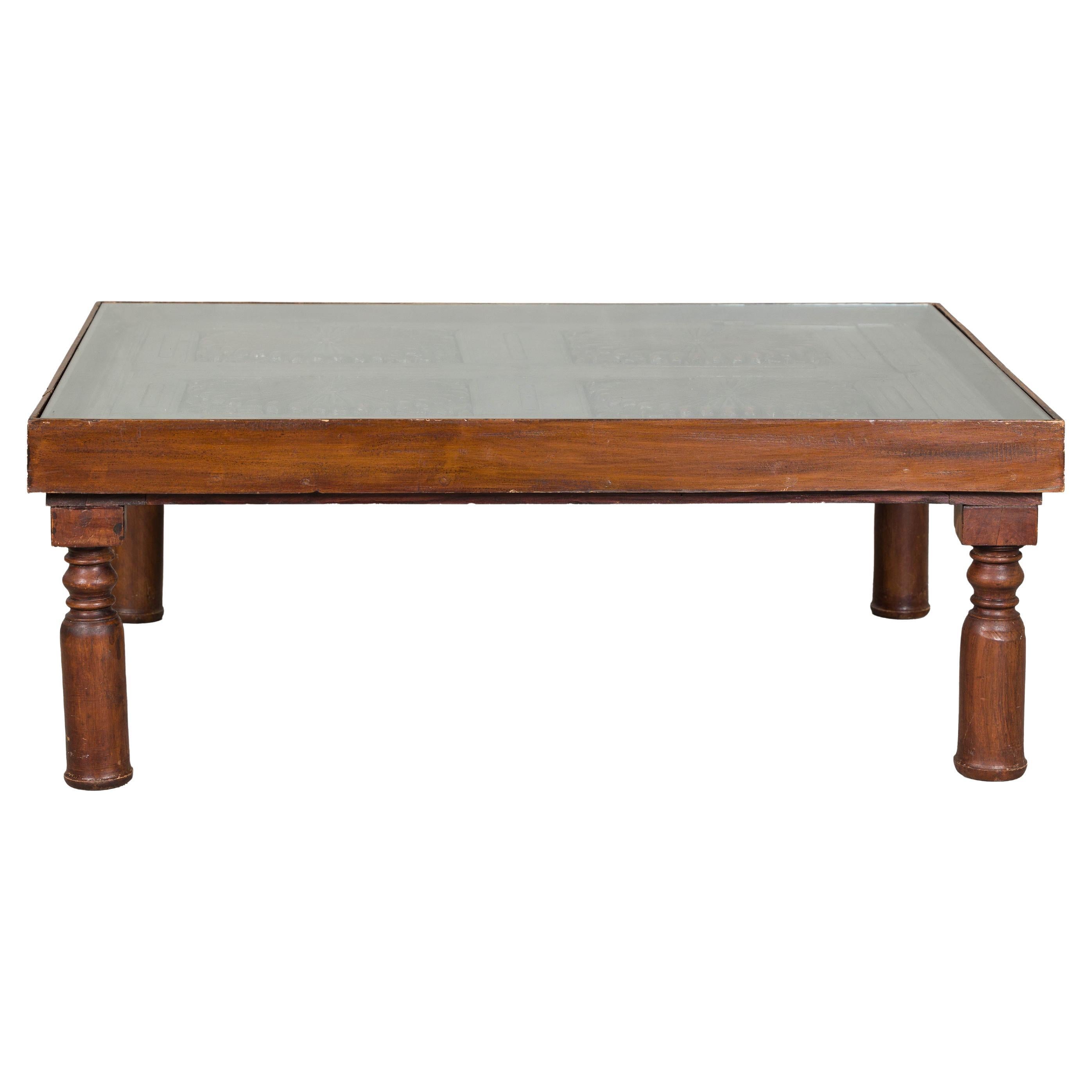 Ancien volet colonial hollandais transformé en table basse avec plateau en verre