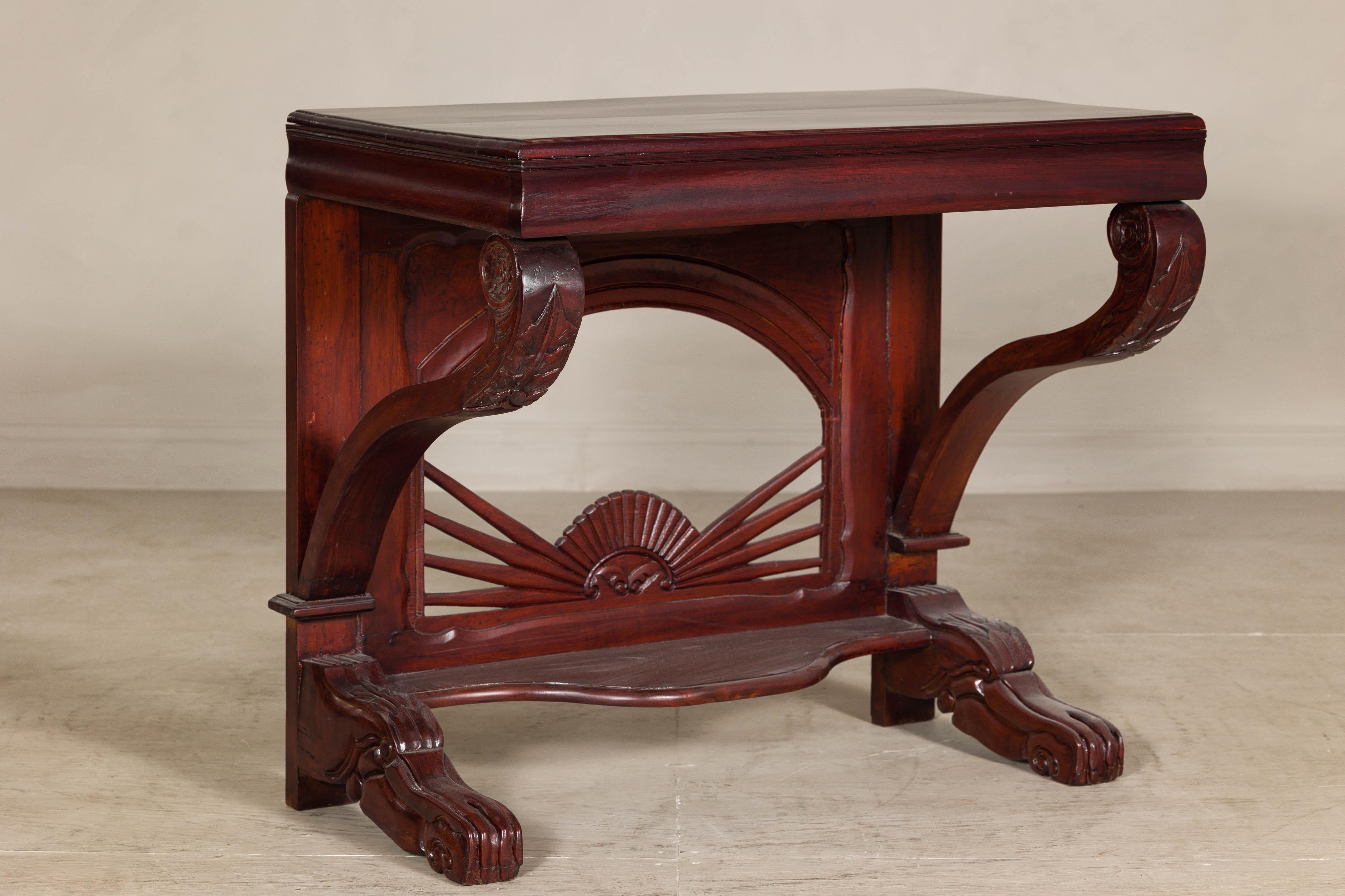 Cette table console ancienne de style Coloni hollandais, fabriquée à la fin du XIXe siècle ou au début du XXe siècle, est un exemple frappant d'artisanat raffiné et de design élégant. Fabriqué en bois de teck durable, il présente une finition laquée