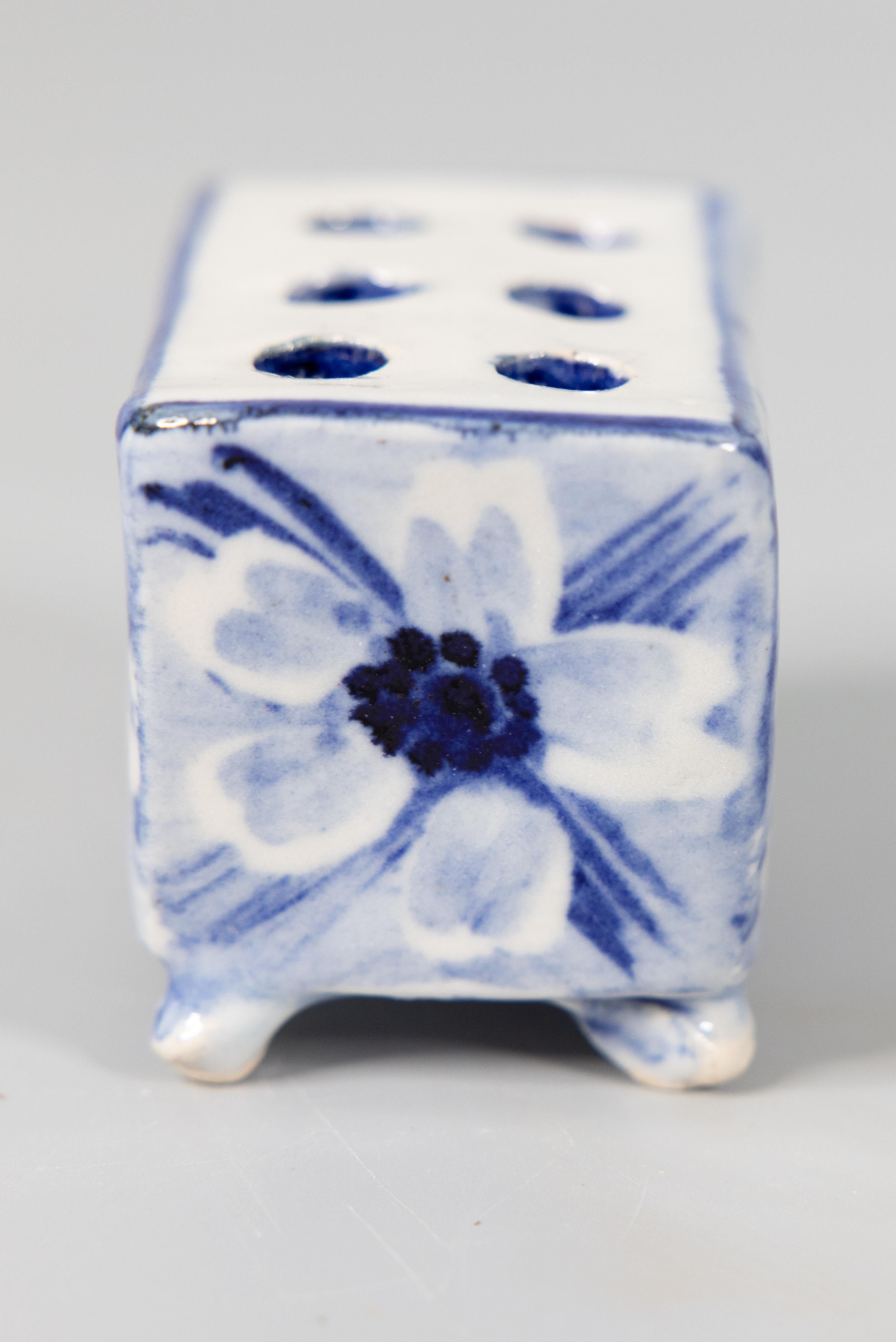 A fine antique Dutch Delft faience hand molded flower brick or flower frog vase. This charming footed flower pot has a hand painted floral design in the traditional Delft colors of cobalt blue and white. It would be lovely with your favorite flowers