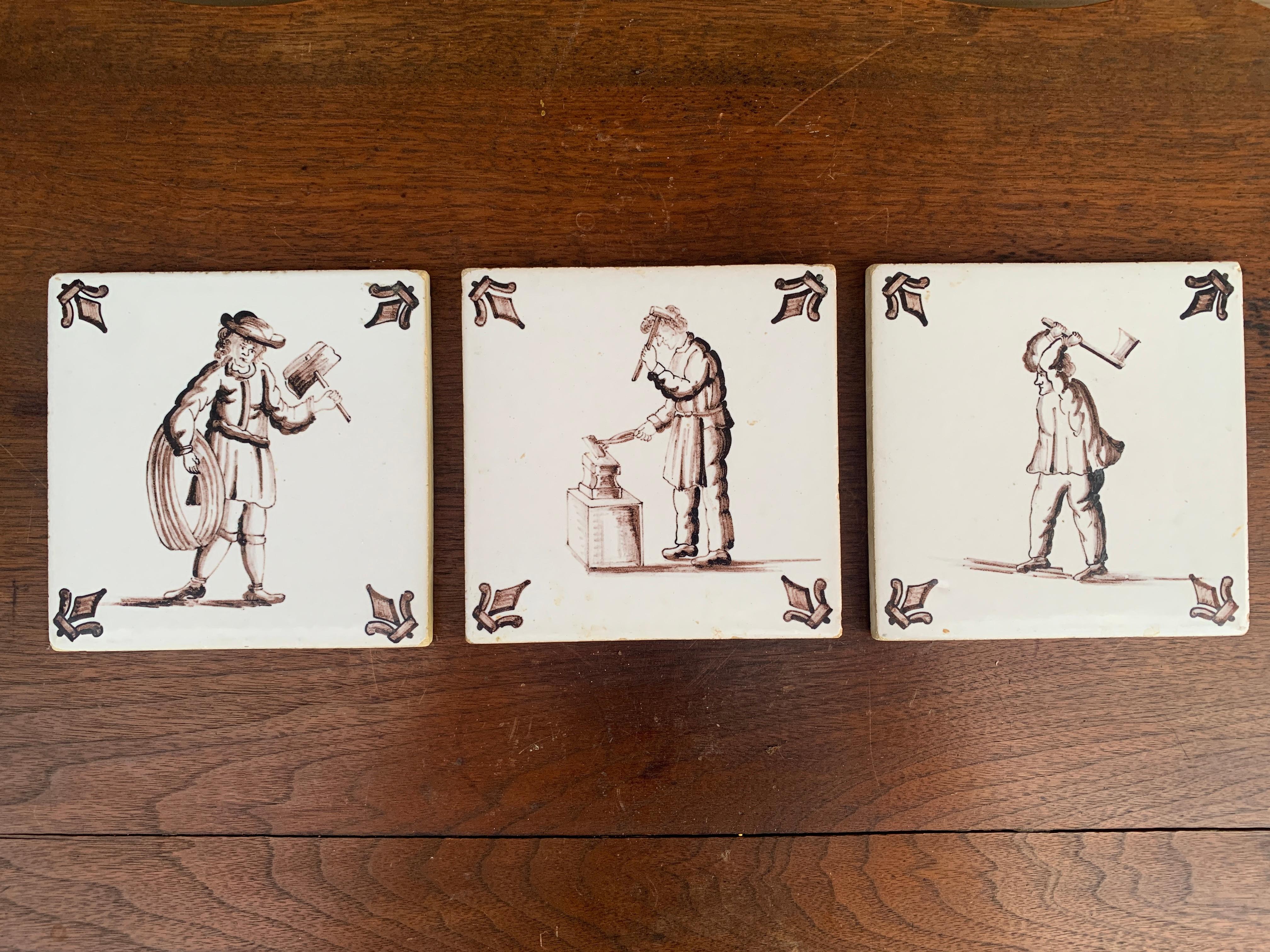 Ein wunderschönes Set aus drei handbemalten braunen und weißen Keramikfliesen im Stil von Delft, auf denen Handwerker und Gewerbetreibende abgebildet sind. Sie eignen sich hervorragend als Untersetzer.

Holland, ca. Mitte des 19. Jahrhunderts

Maße: