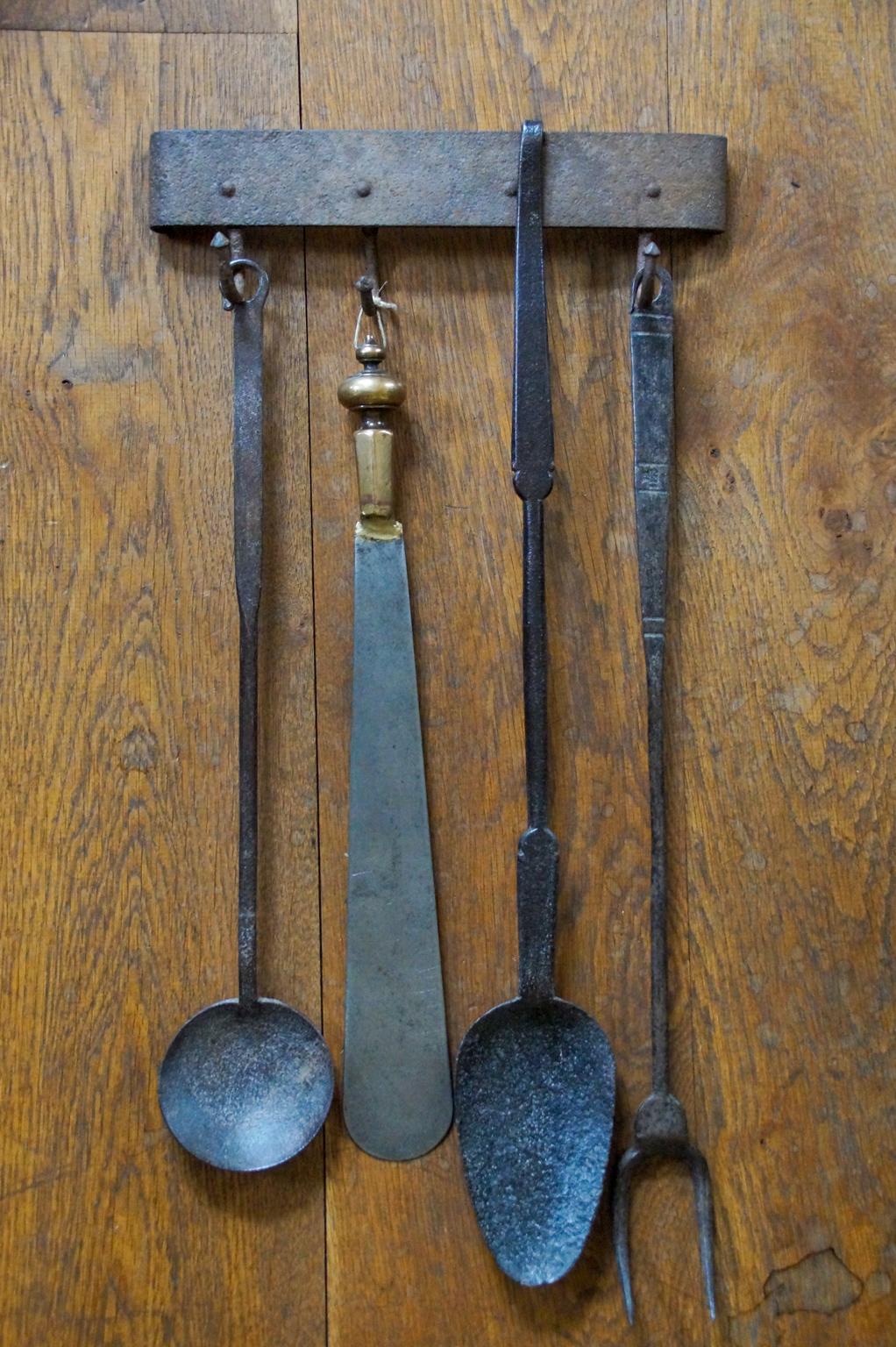 Beautiful 17th-18th century Dutch Louis XIV fireplace tool set. The set consists of a hanger and four fire irons and kitchen tools, all made of wrought iron and hand forged. The spatula has a bronze handle. The tool set is in a good condition and is