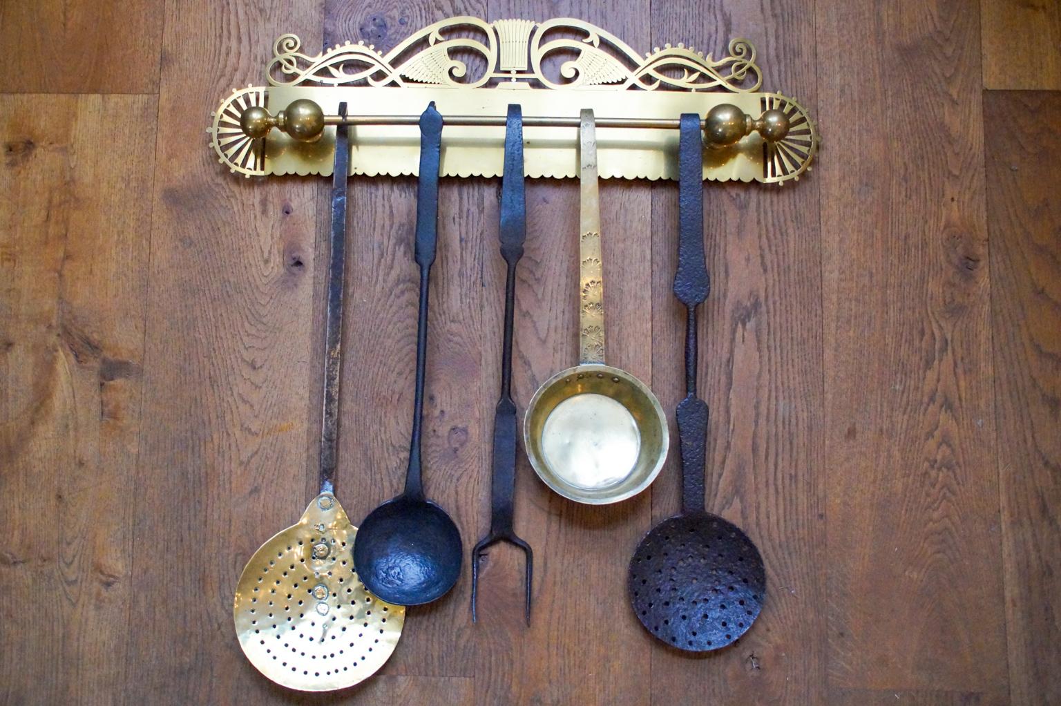 Beautiful 18th-19th century Dutch Louis XV fireplace tool set consisting of a hanger and five fire irons and kitchen tools. From left to right is included a brass skimmer with a wrought iron handle, a wrought iron ladle, a wrought iron tasting fork,
