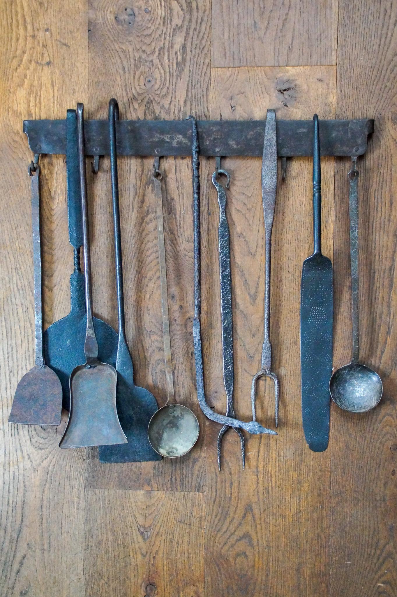 18th - 19th century Dutch Louis XV fireplace tool set consisting of two tasting forks, a poke, several shovels, a decorated spatula, several spoons (of which one is decorated) and a hanger. The set is also made of wrought iron. They are in a good