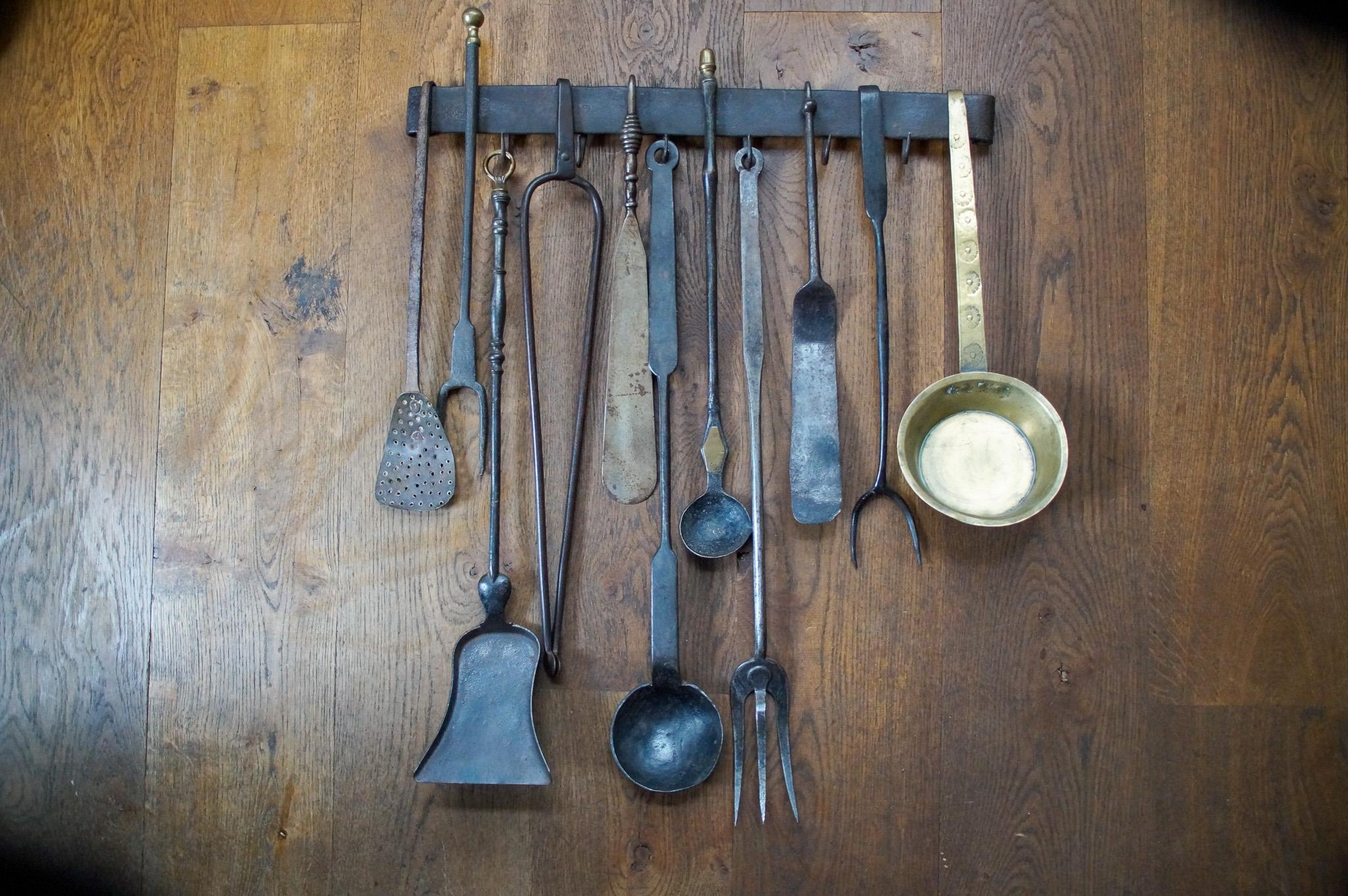 18th - 19th century Dutch neoclassical fireplace tool set consisting of a fireplace tongs, three tasting forks, 3 spoons, a skimmer, a shovel, two spatulas and a hanger. The set is also made of wrought iron and some brass. They are in a good