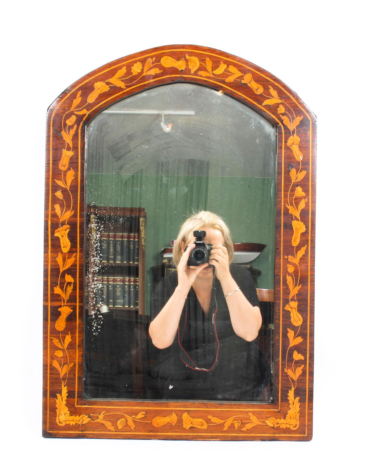 This is a very beautiful antique Dutch flame mahogany and marquetry arched top wall mirror, circa 1830 in date.

The mahogany frame is beautifully inlaid with a continuous marquetry border of trailing flowers and foliage bordered with lines and