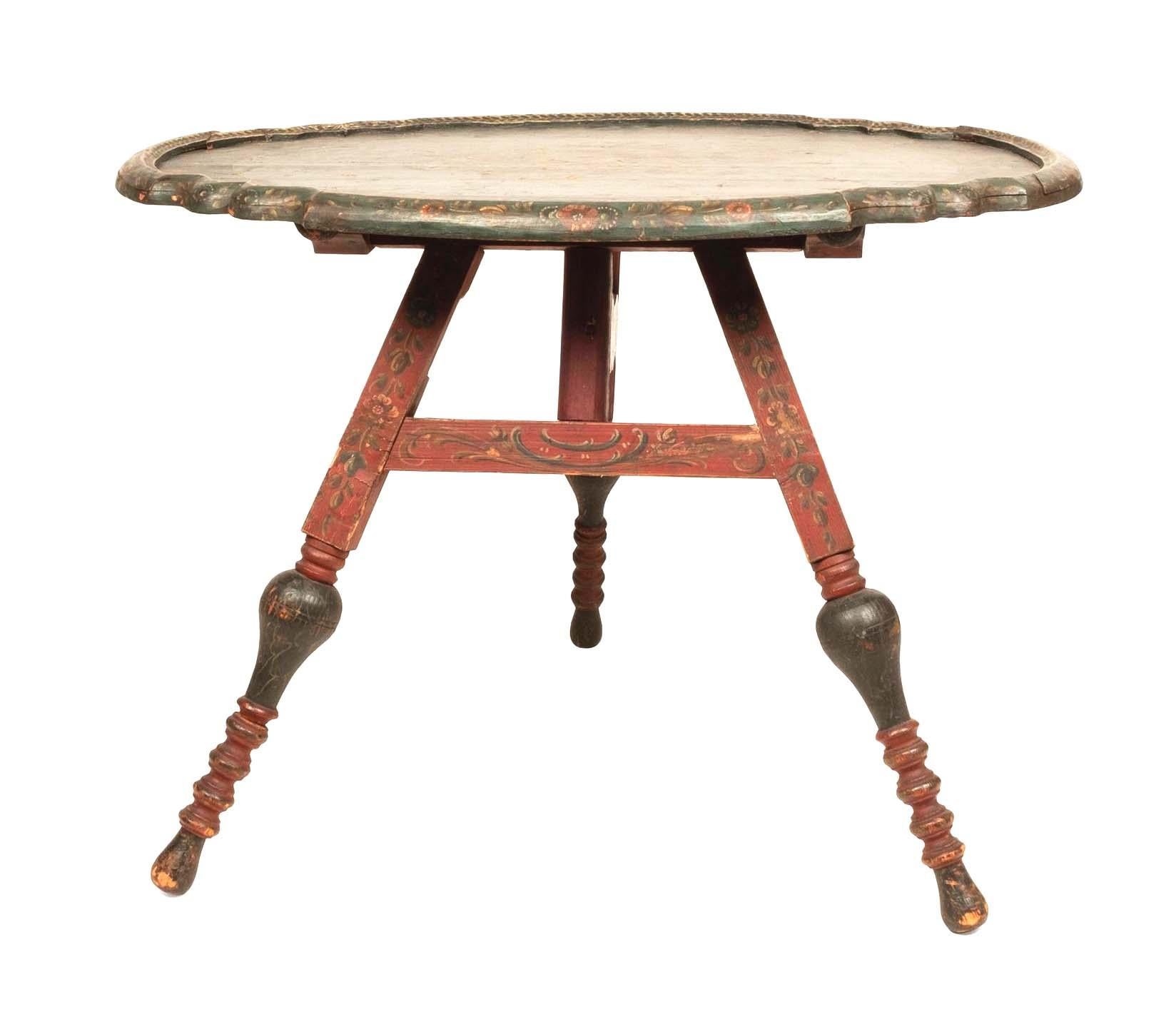 Rare antique Dutch green painted oval tilt top table, Pennsylvania, 19th Century.
The top features hand painted floral designs. The bottom features red paint with carved figural supports and a central hand painted religious scene.

Dimensions
21