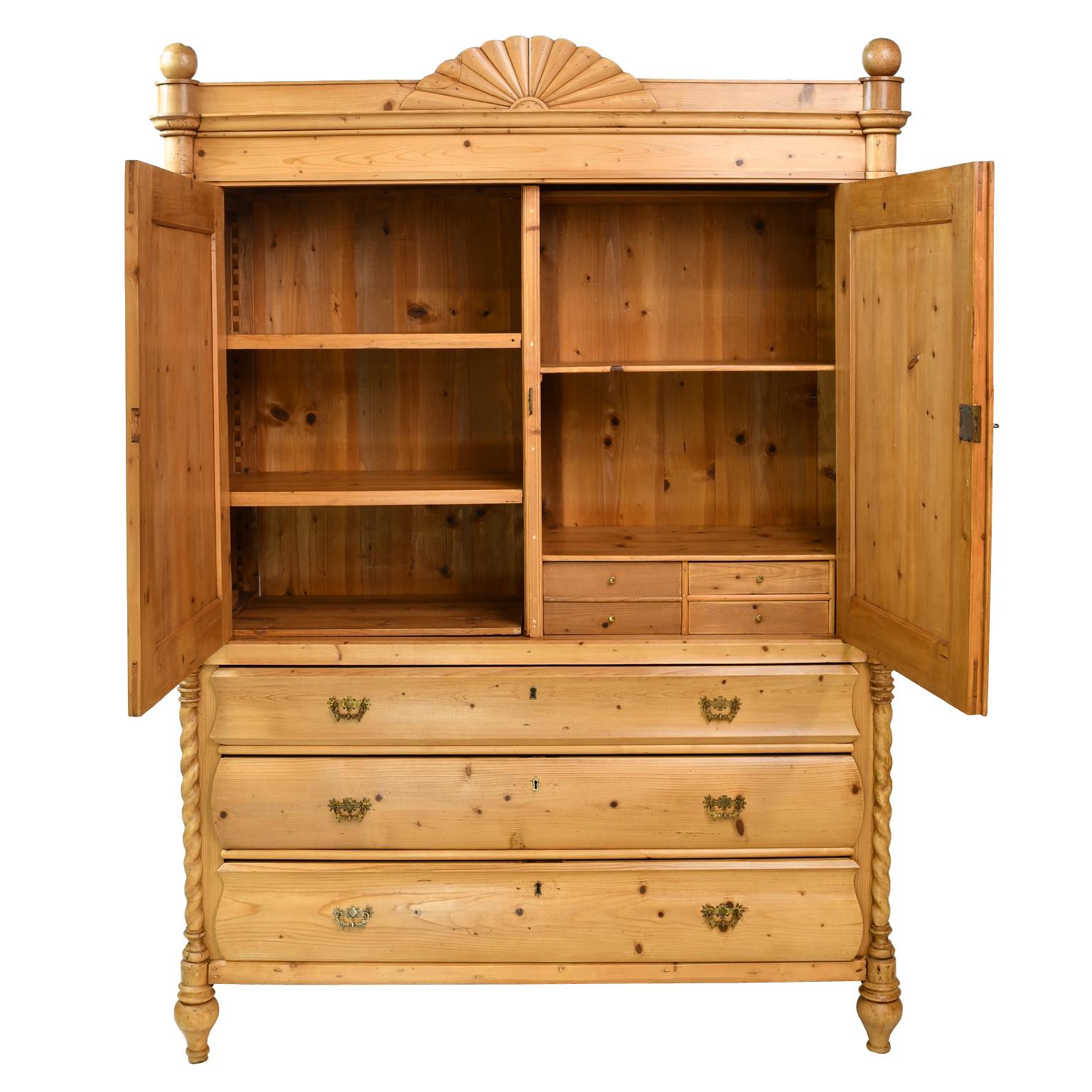 It is seldom we see an antique pine linen press of this quality and charm! From the Netherlands, a lovely linen press in light honey-colored pine with two paneled doors over three long storage drawers, featuring a carved sunburst pediment top