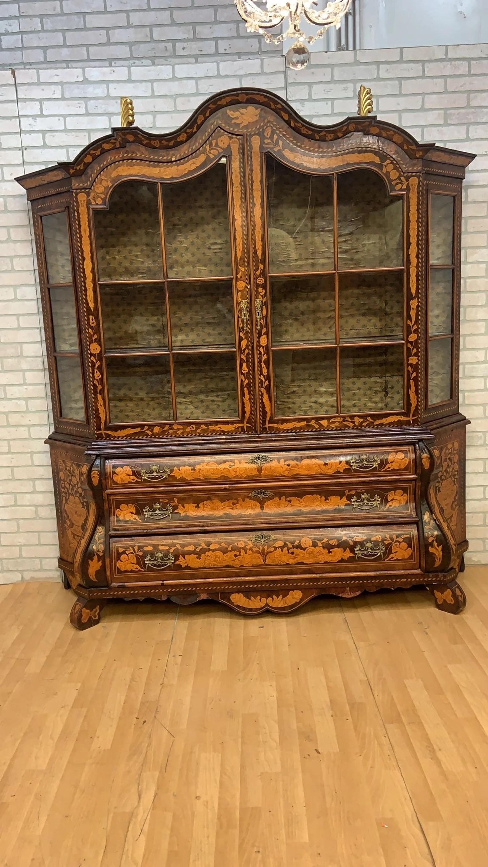 Antique Dutch Marquetry Cabinet

This exquisite 19th Century Dutch Marquetry Cupboard showcases the intricate craftsmanship of its era, featuring two elegant glass doors that provide a glimpse into the beautifully arranged interior. The top section