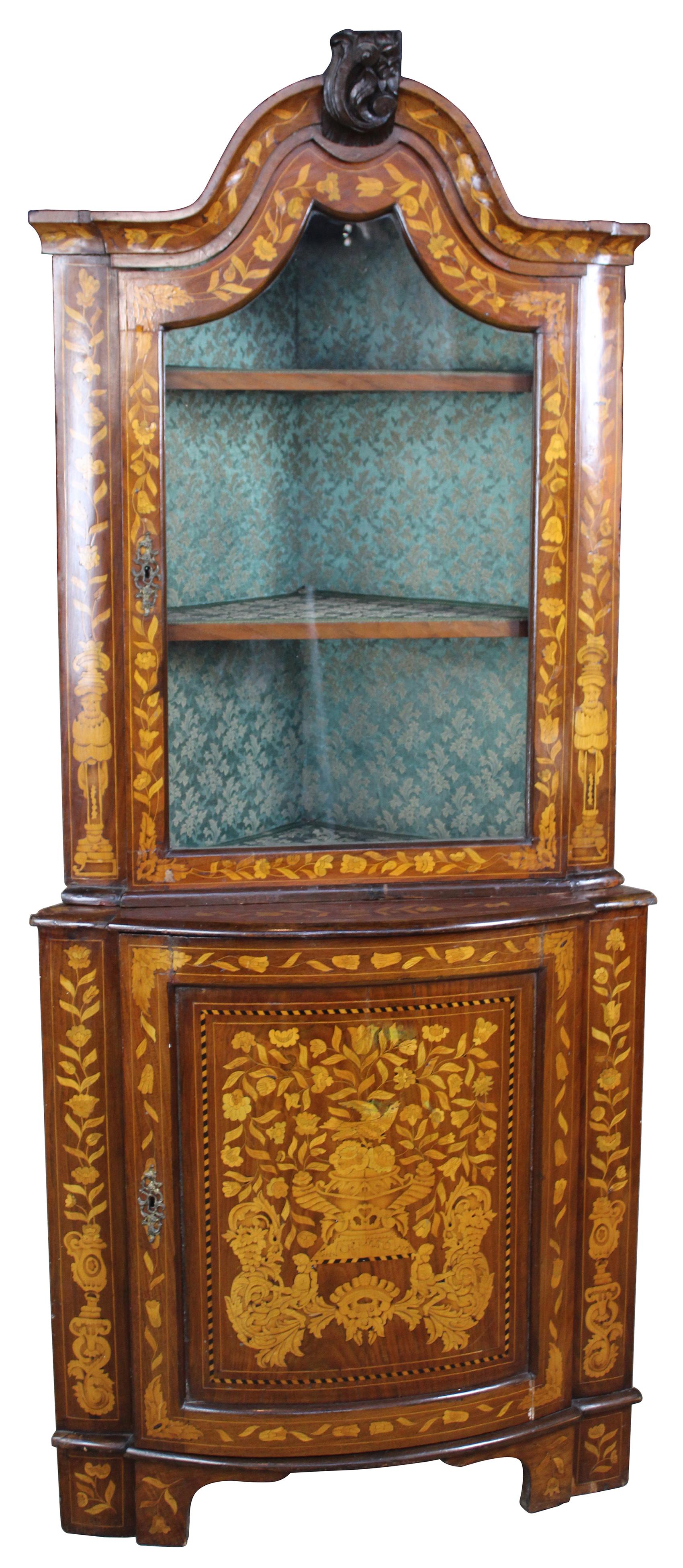 Antique mid-19th century Dutch Marquetry corner cabinet or cupboard. Made of walnut with intricately detailed fruitwood inlay showing flowers, vases, figures and other ornamental detail. Features three interior shelves for display lined with green