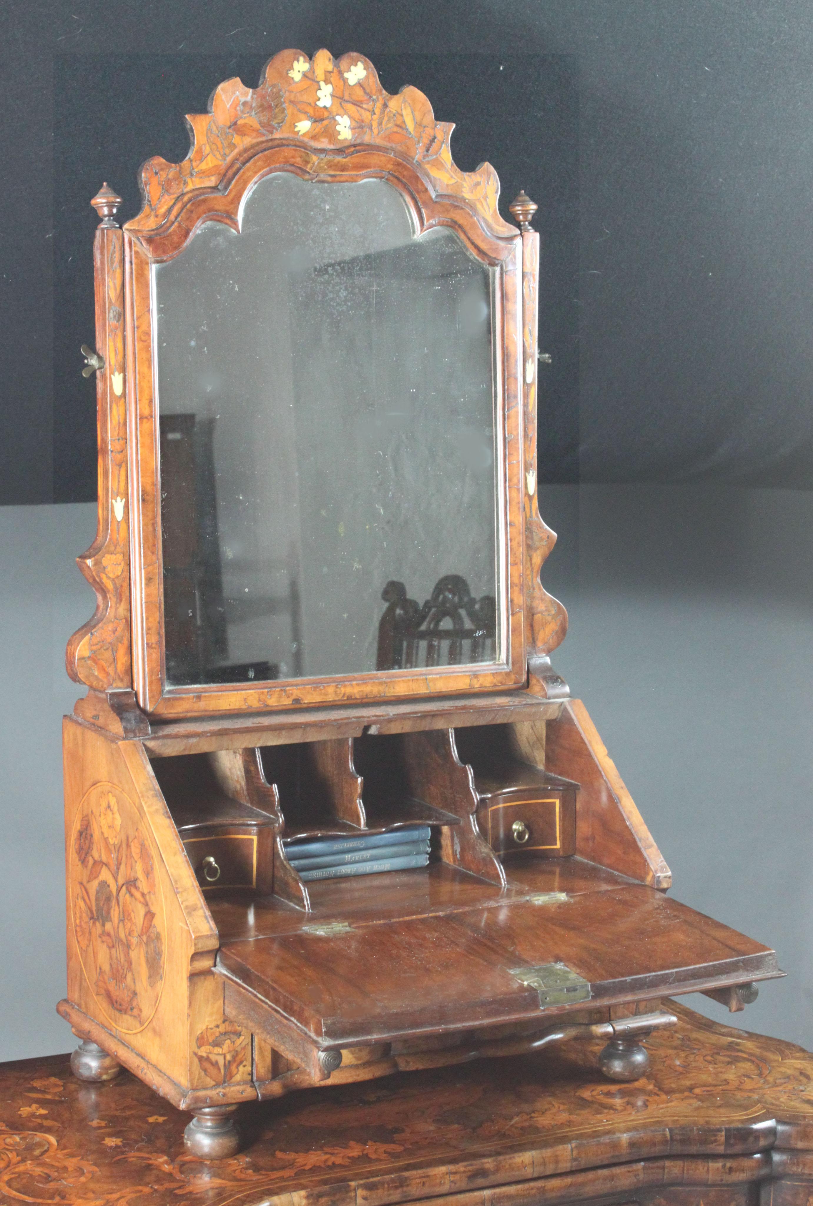 An exceptional Dutch marquetry walnut toilet mirror with flower inlays in bone and woods. Original colour and patina. Attractive shaping to the mirror frame and drawer front. Fitted as a small writing desk complete with pigeon holes and interior