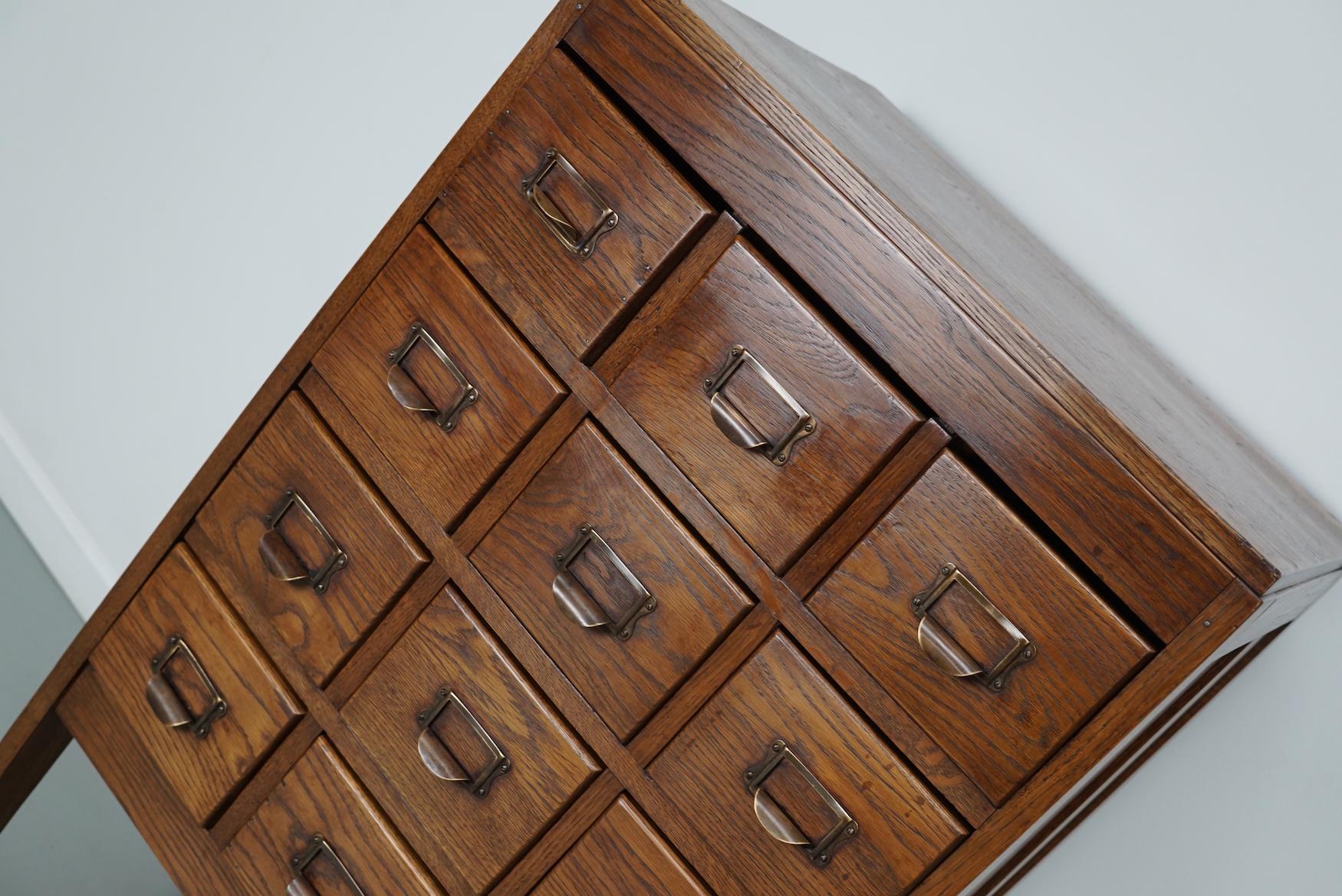 This apothecary / filing cabinet was produced during the 1930s in the Netherlands. This piece features 12 drawers on slim legs. The interior dimensions of the drawers are: DWH 47 x 16 x 8.5 / 12.5 cm.