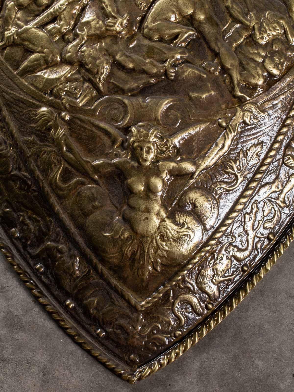 A striking Dutch parade shield circa 1880 featuring a Baroque style scene of warring figures. The inverted teardrop shape has a double border of ribbon twist with a band of male and females interspersed with dragons. In the center at the top is a