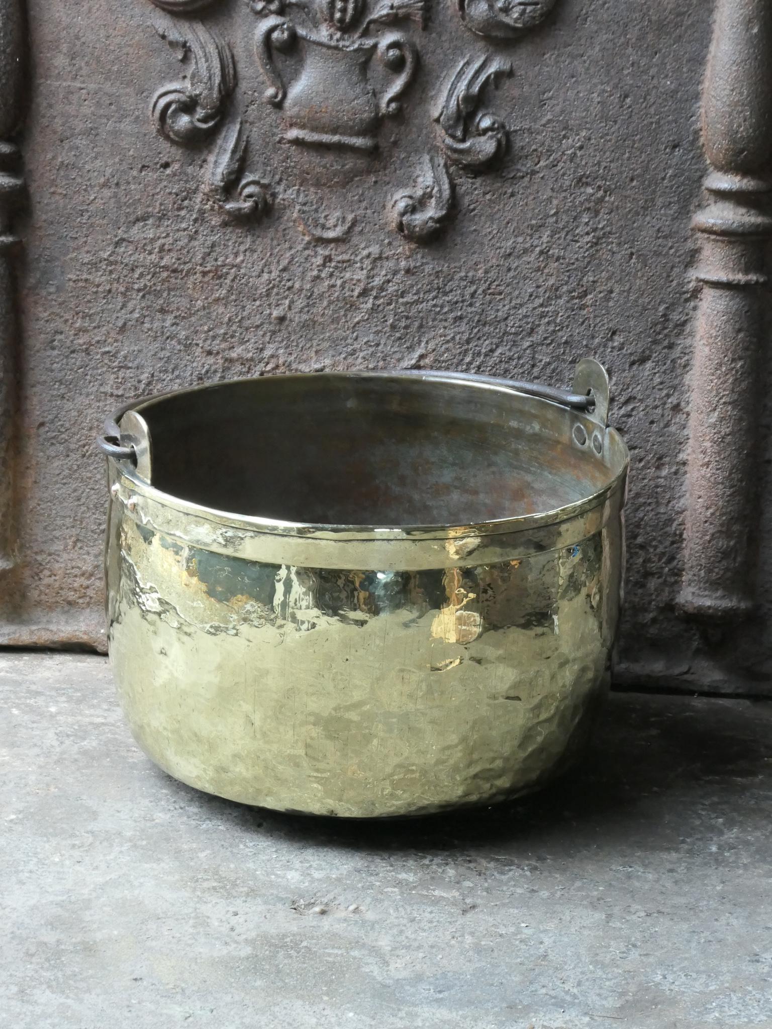 18th century Dutch log basket. The firewood basket is made of polished brass and has a wrought iron handle. Also called 'aker'. Used to draw water from the well and cook over an open fire.

The log holder is in a good condition and is fully