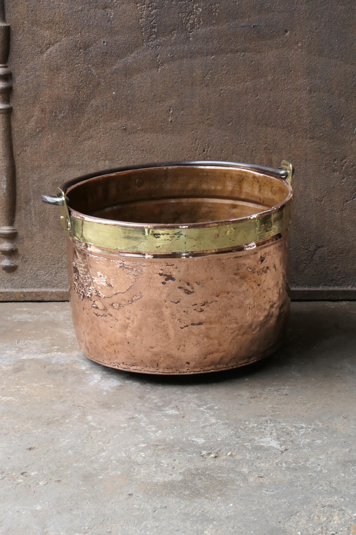 18th-19th century Dutch neoclassical log basket. The firewood basket is made of polished copper with a polished brass ring and has a wrought iron handle. Also called 'aker'. Used to draw water from the well and cook over an open fire.

The log
