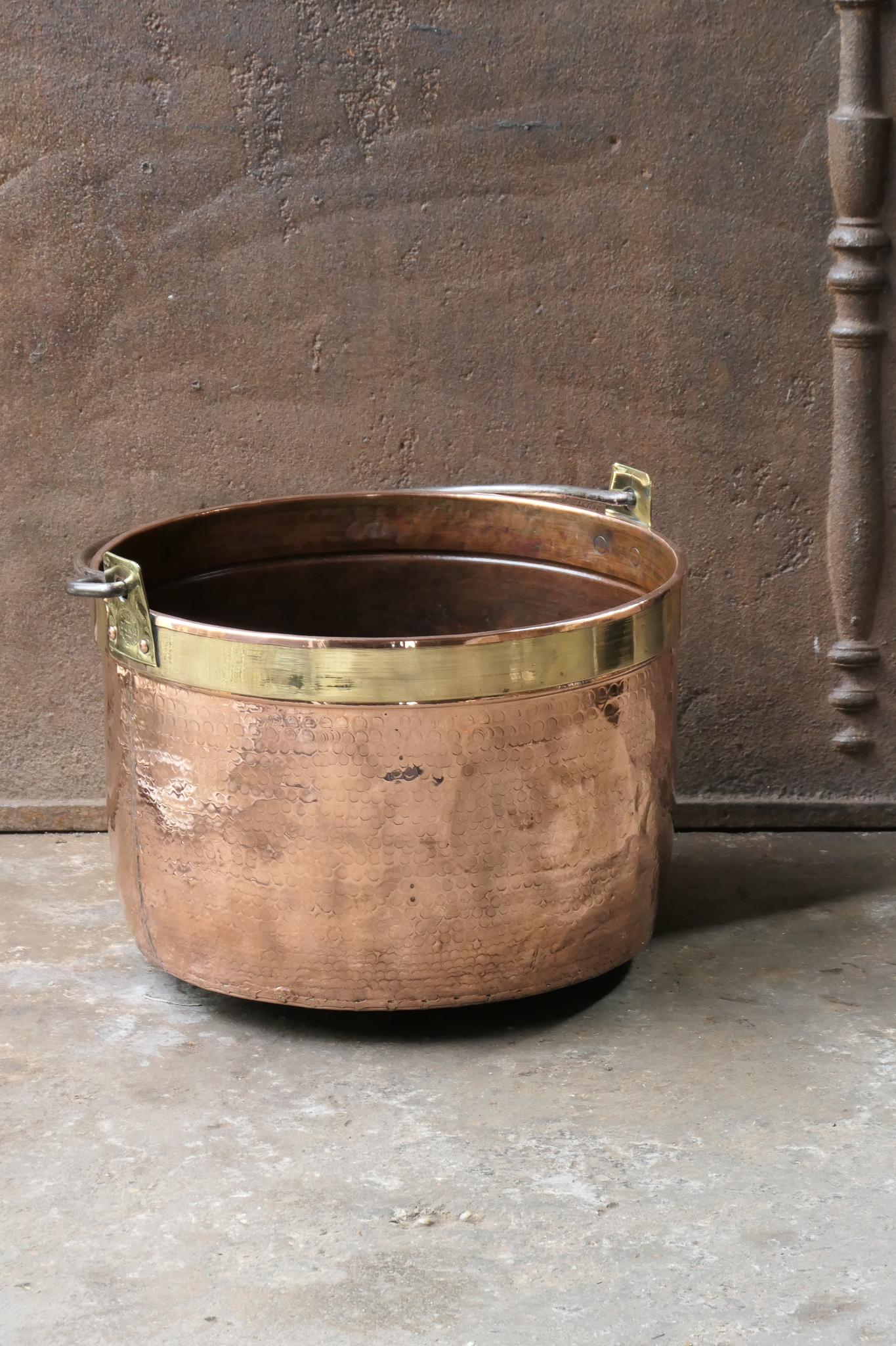 18th - 19th Century Dutch neoclassical log basket. The firewood basket is made of polished copper with a polished brass ring and has a wrought iron handle. Also called 'aker'. Used to draw water from the well and cook over an open fire.

The log