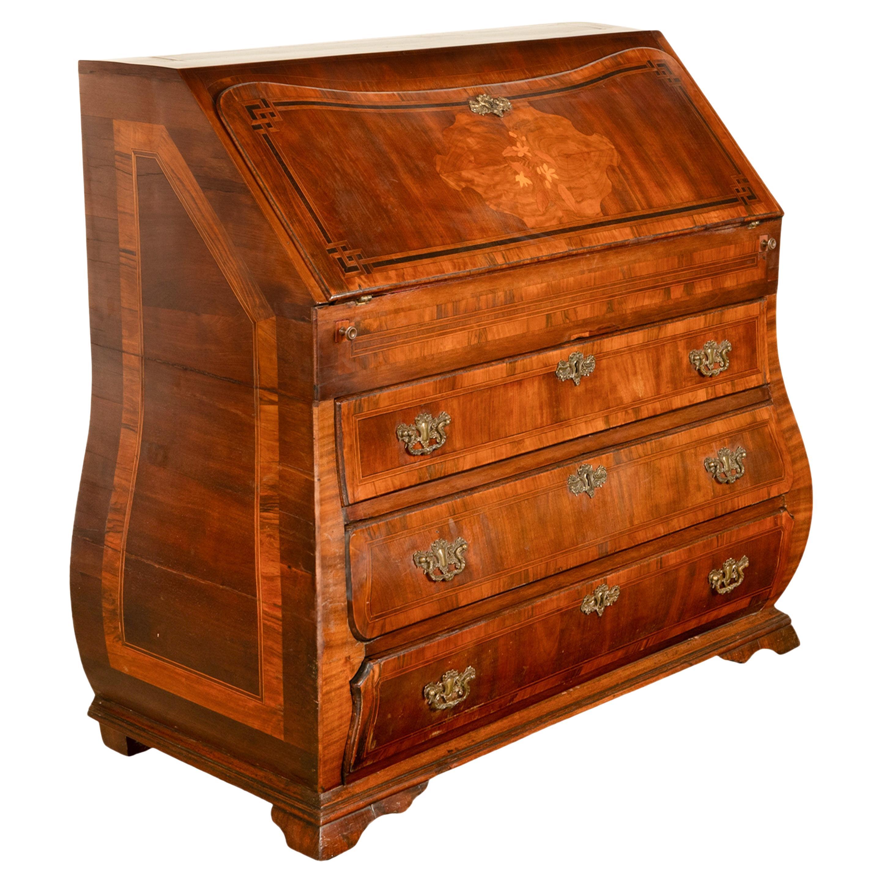 A fine 18th century Dutch Rococo walnut inlaid marquetry bombe shaped desk, circa 1780.
The desk top is inlaid with a satinwood panel and having corresponding panels to the sides, the desk is of bombe shape and has a fall front that is finely inlaid
