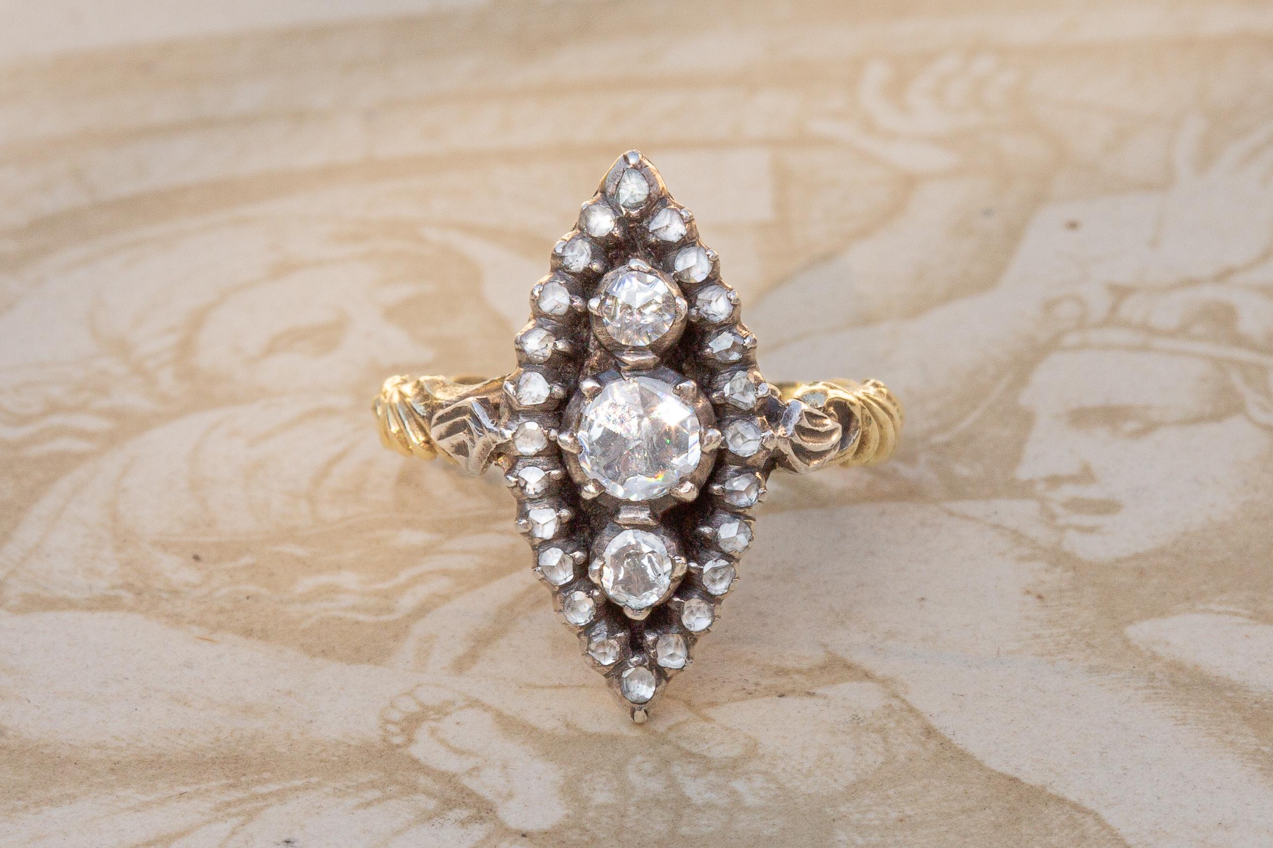 This gorgeous navette shaped cluster was made in the Netherlands and dates to around 1900. In the centre of the closed-back cluster are set three bright rose cut diamonds which exhibit lots of fire and sparkle. They are surrounded by a halo of