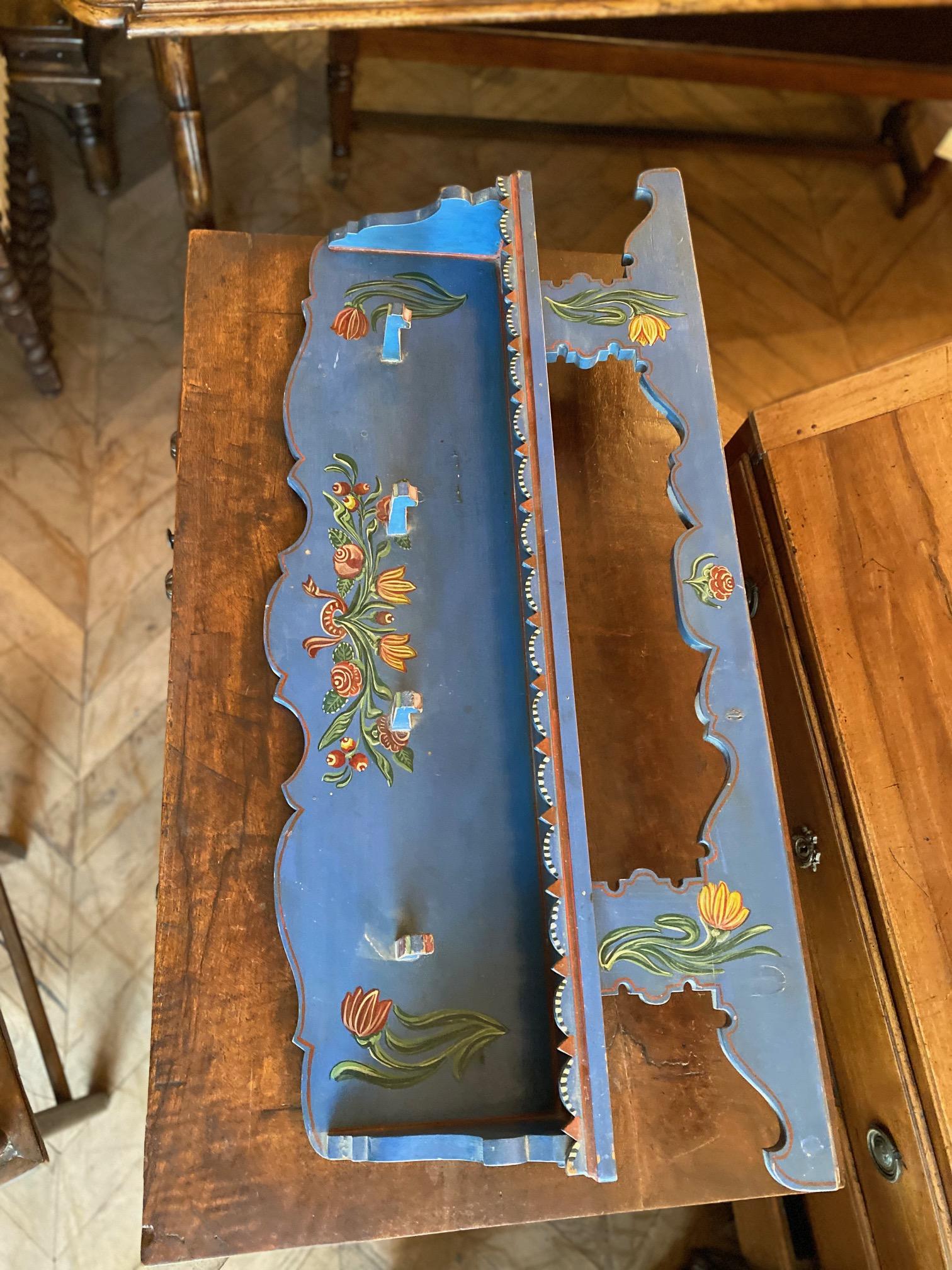 This painted Dutch piece features pegs for hanging coats and storing odd and ends on the top shelf. 

Measurements: 40
