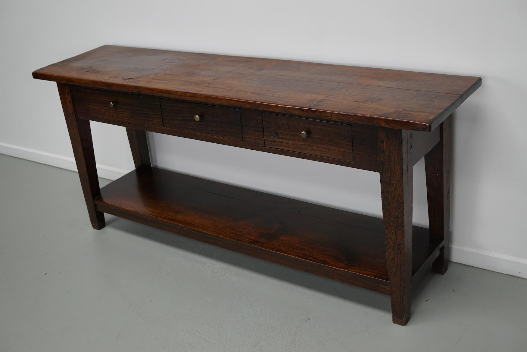 Cette table élégante a été fabriquée en Indonésie. La table a été fabriquée en teck et en chêne indonésiens massifs avec un magnifique motif de grain. Elle a une couleur chaude avec une brillance profonde et la table montre de nombreuses marques