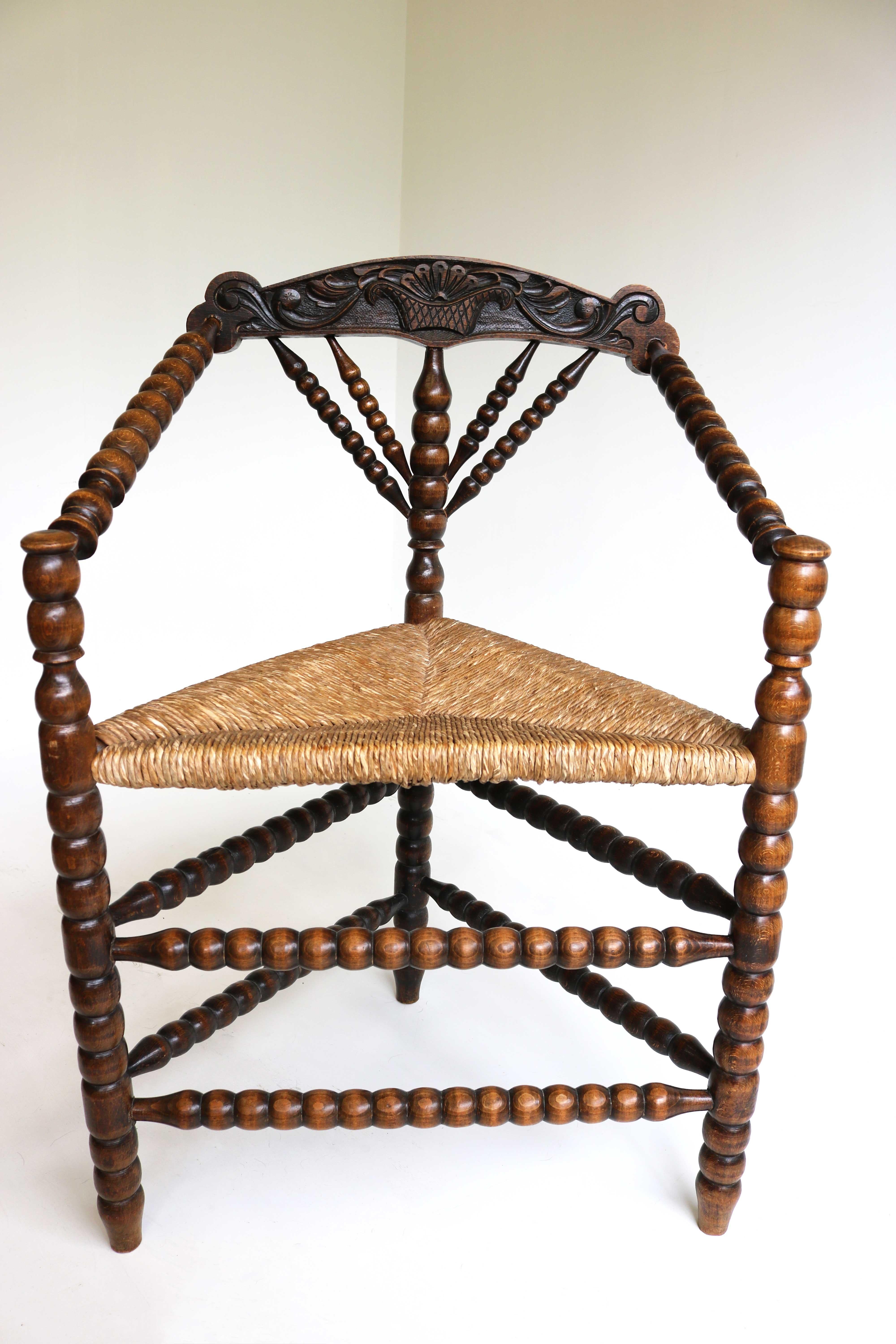Late 19th century bobbin turned wood armchair with rush seat, ca 1900
Manufactured in The Netherlands.
Beautiful antique bobbin/ knitting chair with three legs and with a carved flower basket in the back, very decorative.
This old Dutch chair