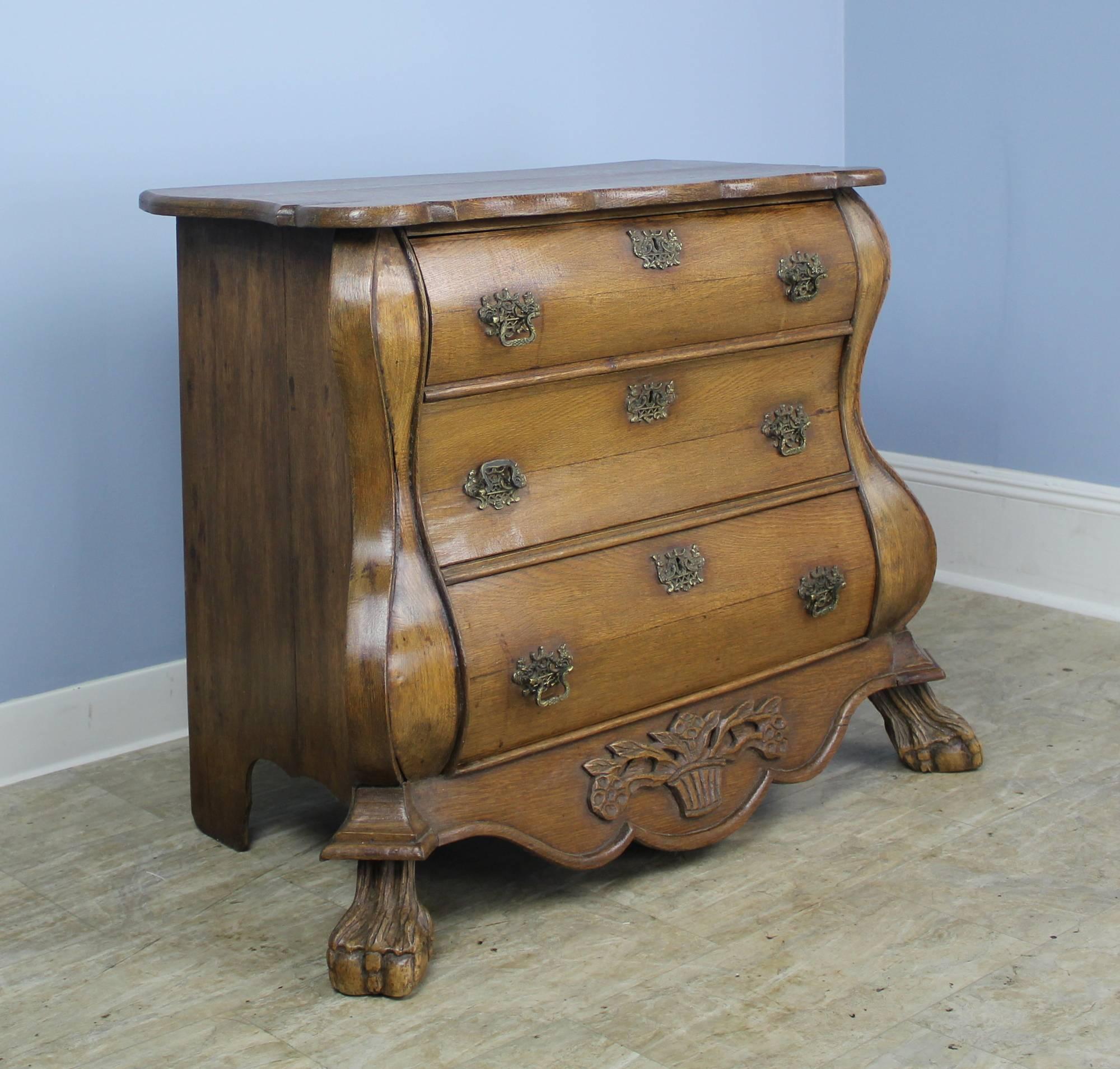Fabulous early Dutch bombe chest, grand in presence. This four drawer bureau is made of mellow walnut with a beautiful color and rich patina. Details of note include all original handles, shaped and decoratively carved apron on the front, and a