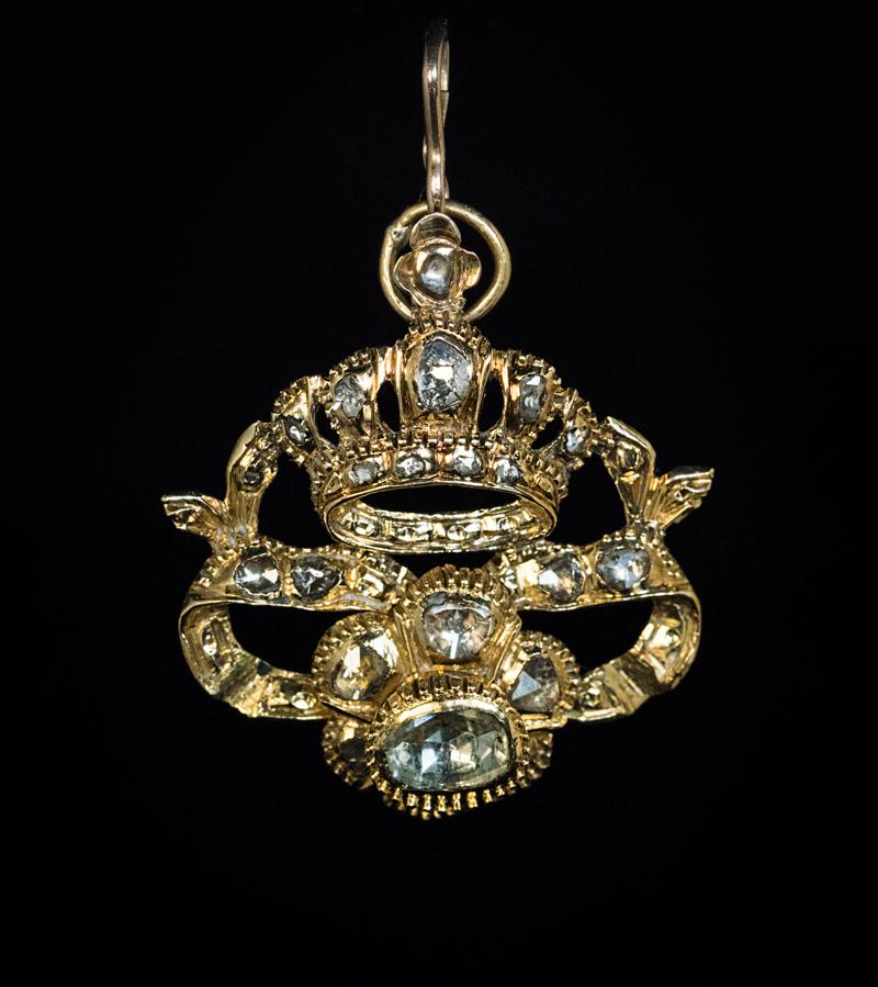 This magnificient and very rare early 18th century Baroque crown & cross pendant is crafted in gold (approximately 14K) and embelished with antique rose cut diamonds backed by silver foil.

The pendant’s crown and cross with ribbons can be detached