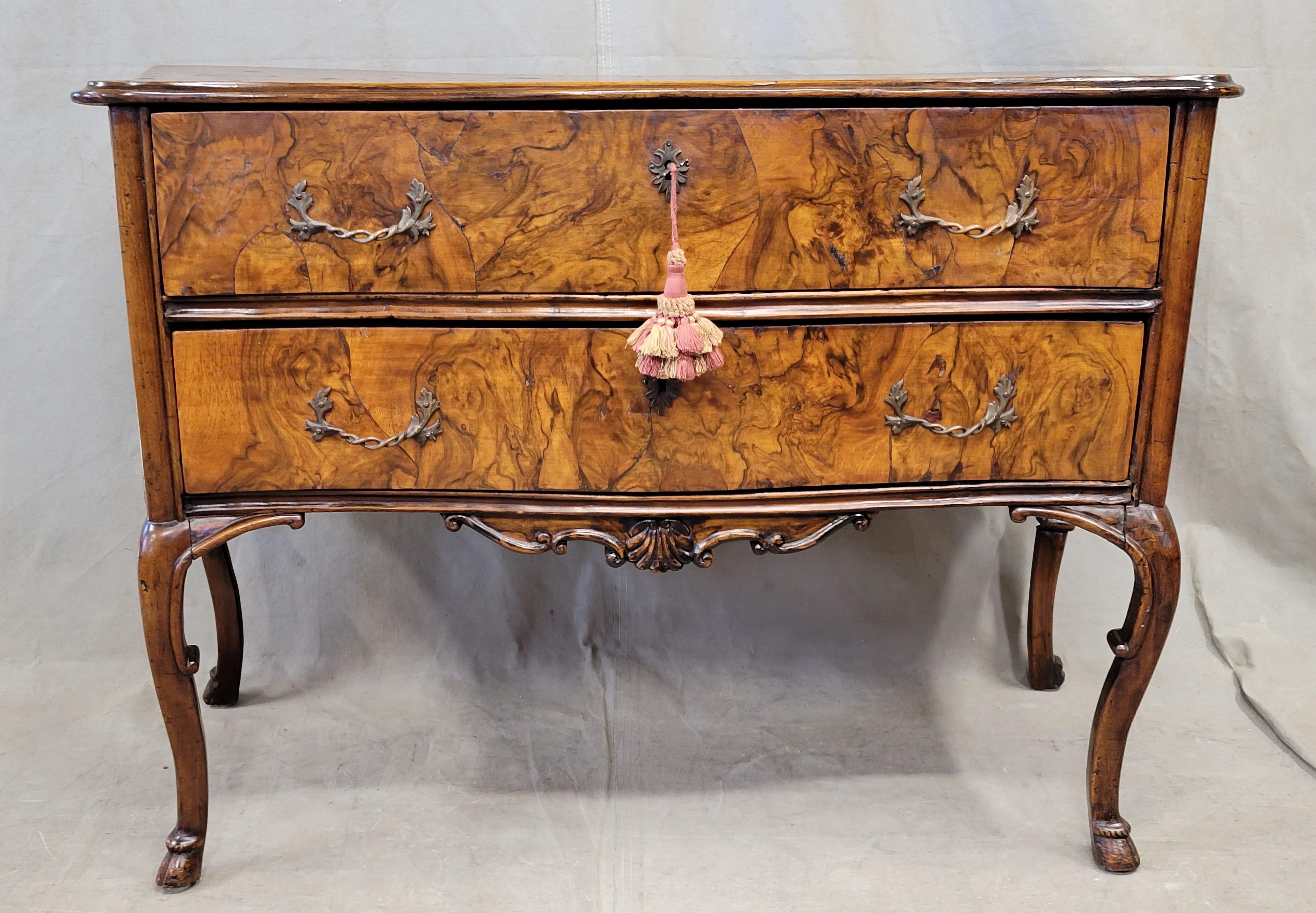 A gorgeous, antique late 1700s or early 1800s French burl walnut commode with cabriole legs and deer hoof feet (pied-de-biche); in the shape of Louis XV commodes but with a more rustic, French country flair. Old fill in the bookmatched walnut burl
