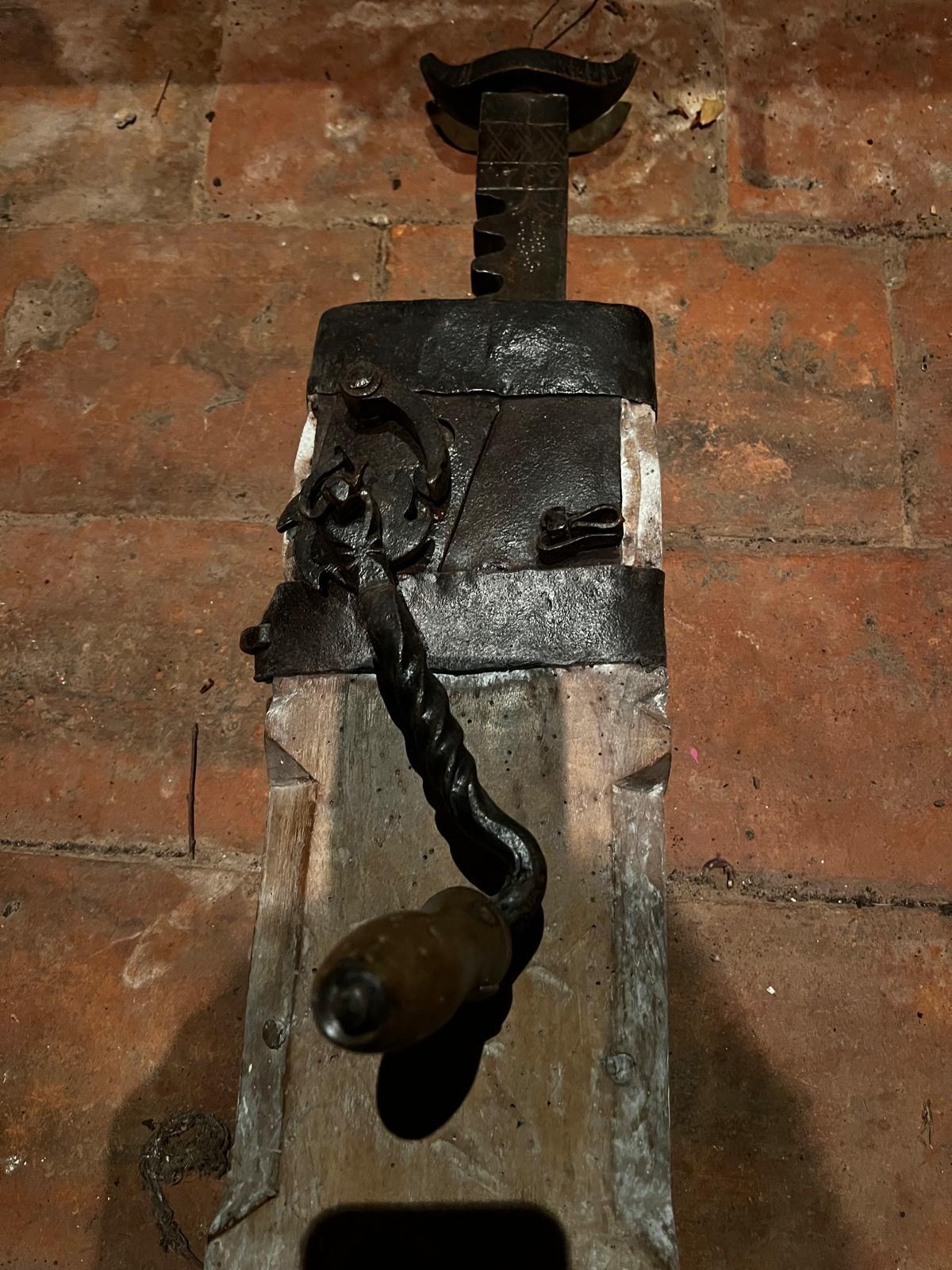 Rare et authentique chèque de roue de chariot autrichien du début du XVIIIe siècle, fabriqué en fer forgé et en bois de chêne. Ce dispositif ingénieux était historiquement utilisé pour soulever et fixer les roues des wagons, afin d'éviter qu'elles