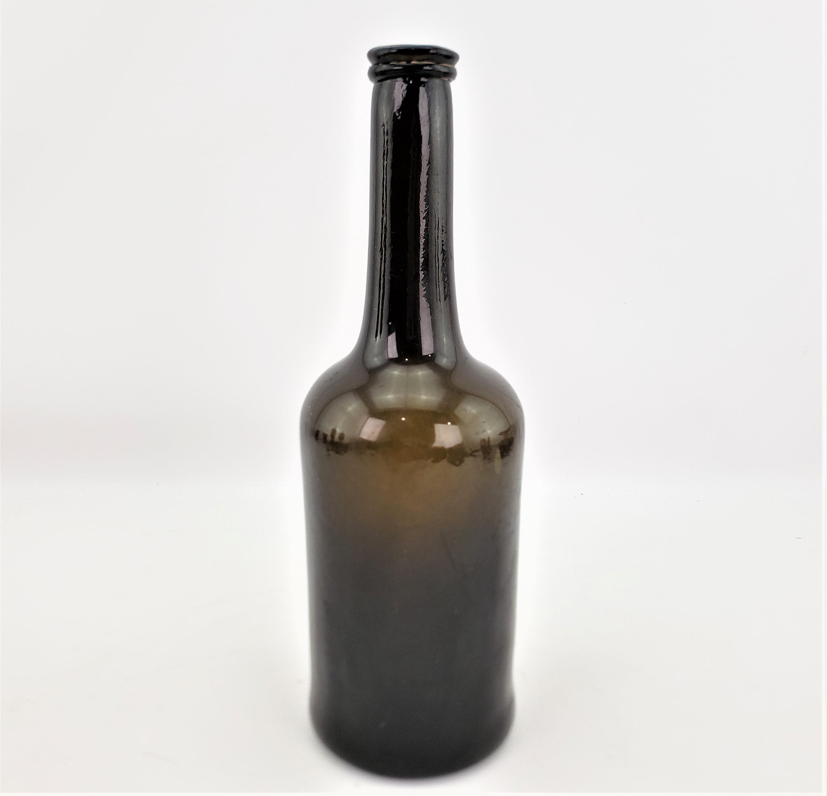 Diese antike, handgefertigte Weinflasche hat keine Herstellermarken, aber vermutlich stammt sie aus England und wurde um 1740 im georgianischen Stil hergestellt. Das Glas ist ein sehr tiefes Olivgrün, das mundgeblasen und zu einer Schlegelform