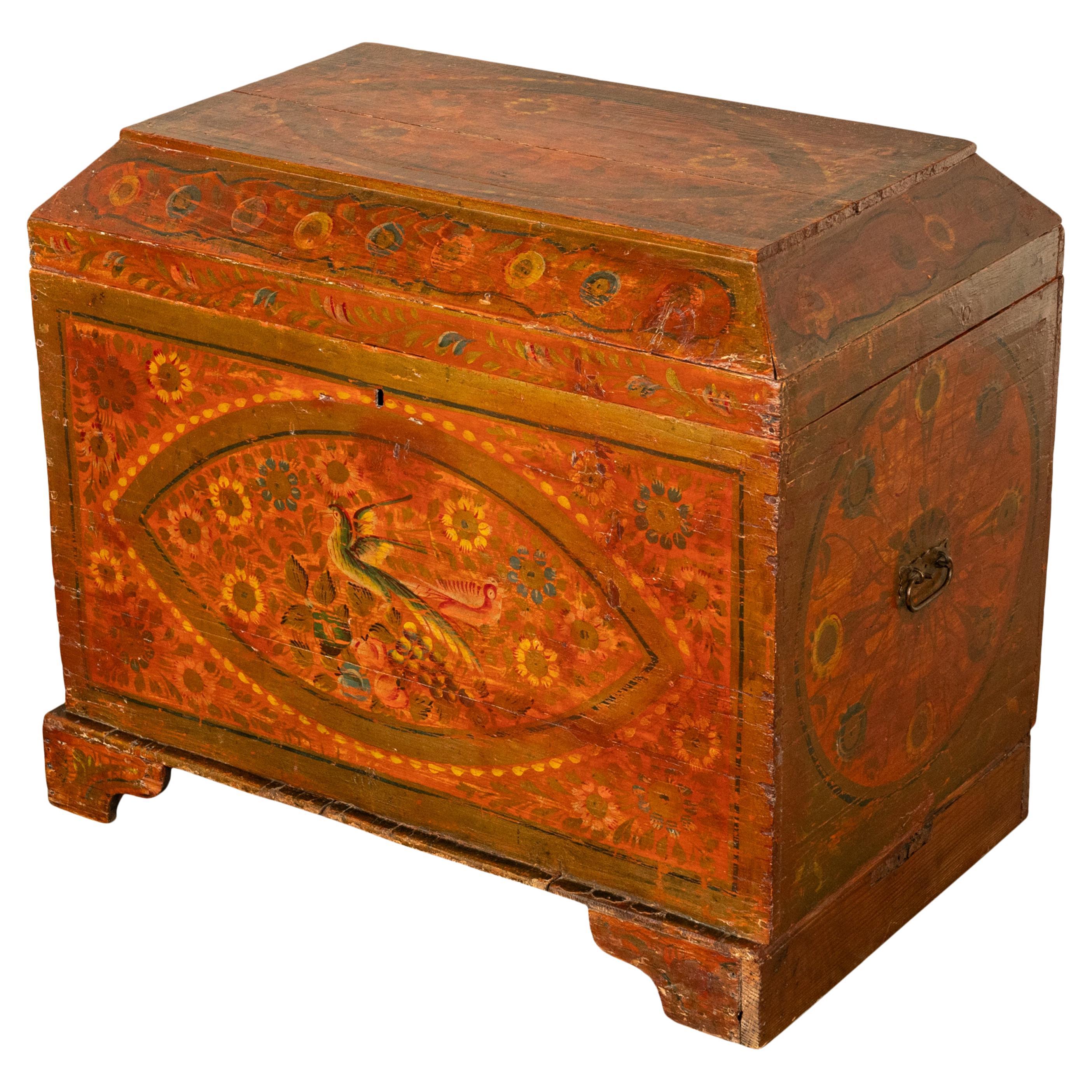 Atractiva cómoda sueca de principios del siglo XIX, pintada a mano y de estilo folclórico, hacia 1820.
La tapa, en forma de sarcófago, encierra un gran espacio para guardar ropa o ropa de cama; el interior de la tapa conserva la pintura original sin