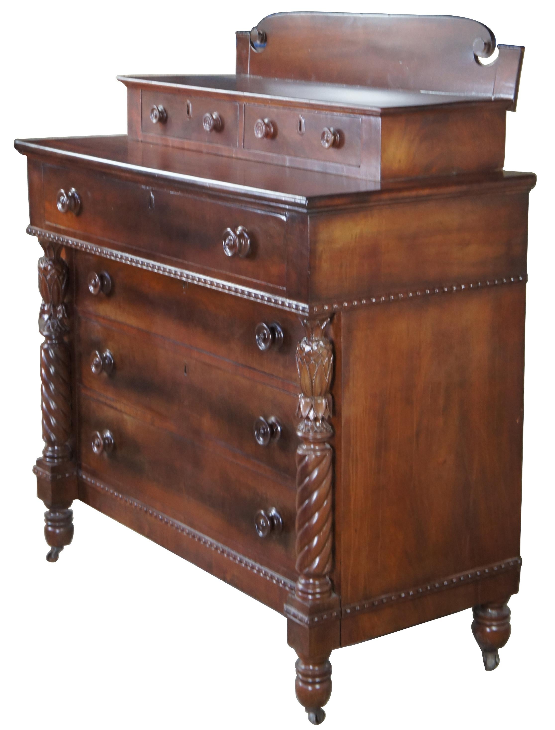 Early 19th Century American Empire finely carved chest of drawers, with pineapple topped, barley-twist columns. A rectangular form made from mahogany with crotch veneer along drawer fronts and stepback design featuring two glovebox drawers. Includes