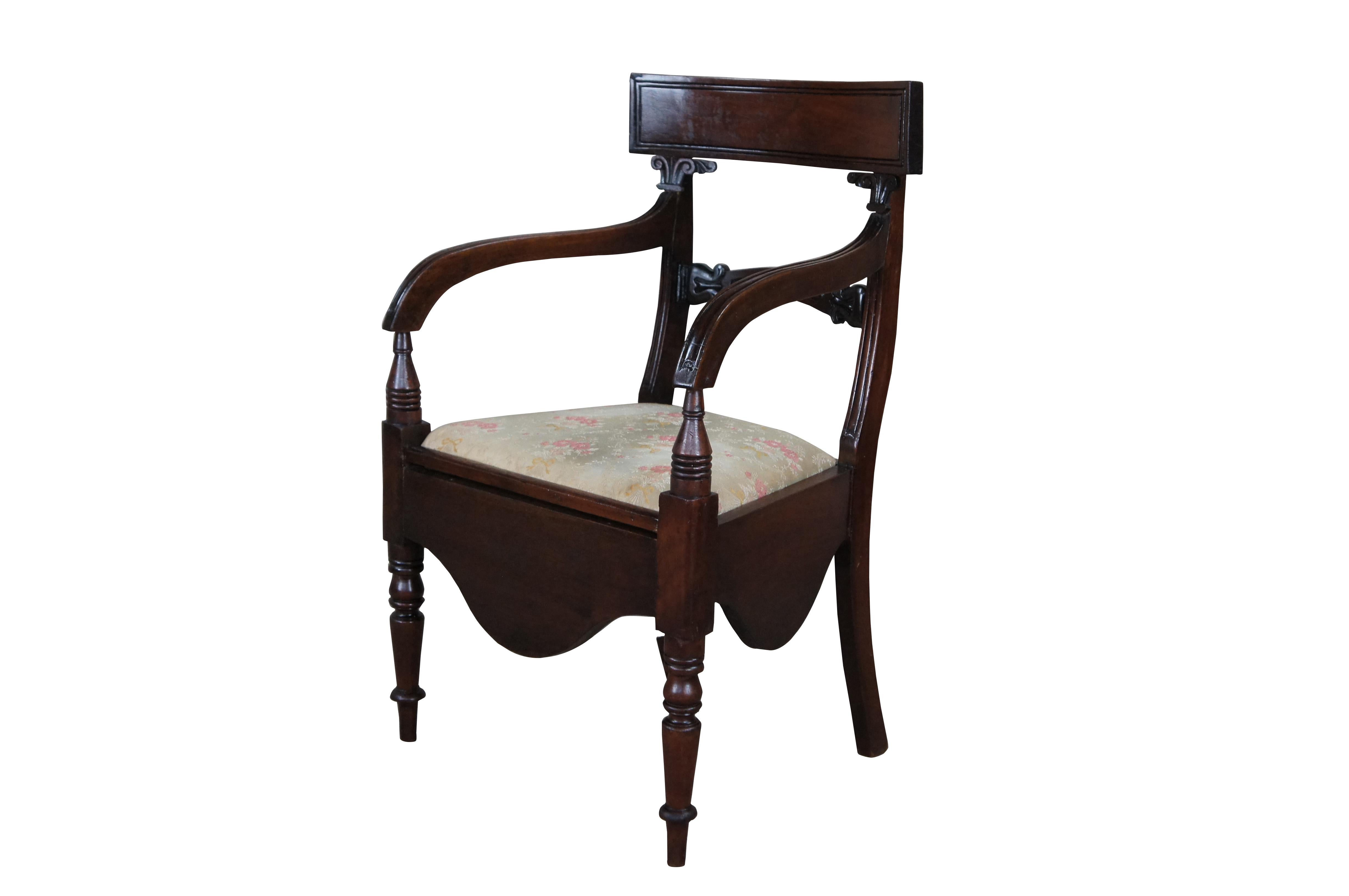 Impresionante cómoda de principios del siglo XIX de la época de la Regencia con orinal, hacia la década de 1820.  Presenta un armazón de caoba con brazos descendentes y detalles tallados sobre patas torneadas y acanaladas que desembocan en pies de