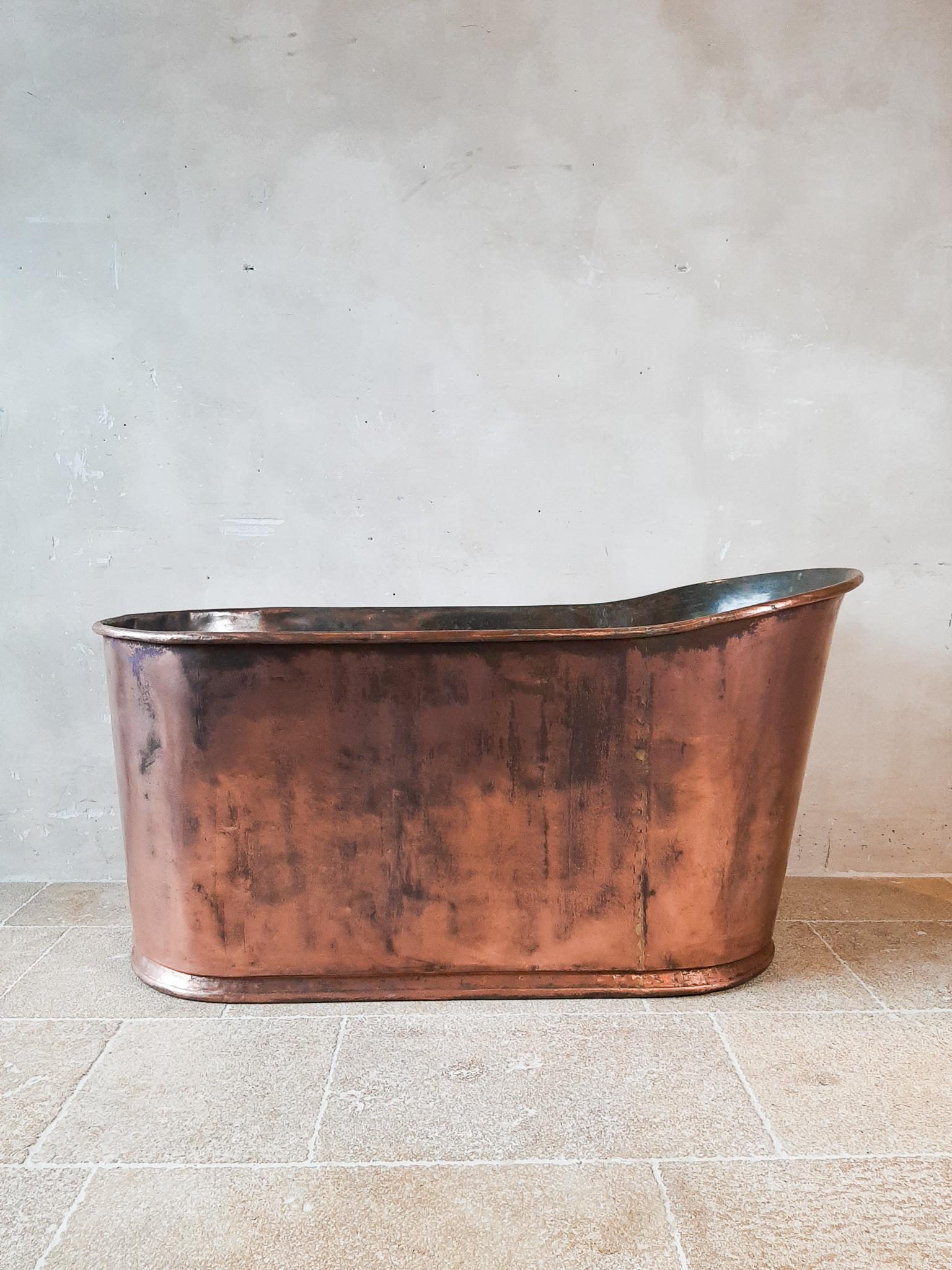 Beautiful antique early 19th century copper bathtub. Made in France in the Empire style. This is an Asymmetrical bathtub that you sit in, which is why this bathtub is quite high.

Measures: 141 cm long, 63 cm wide and 75 cm high.