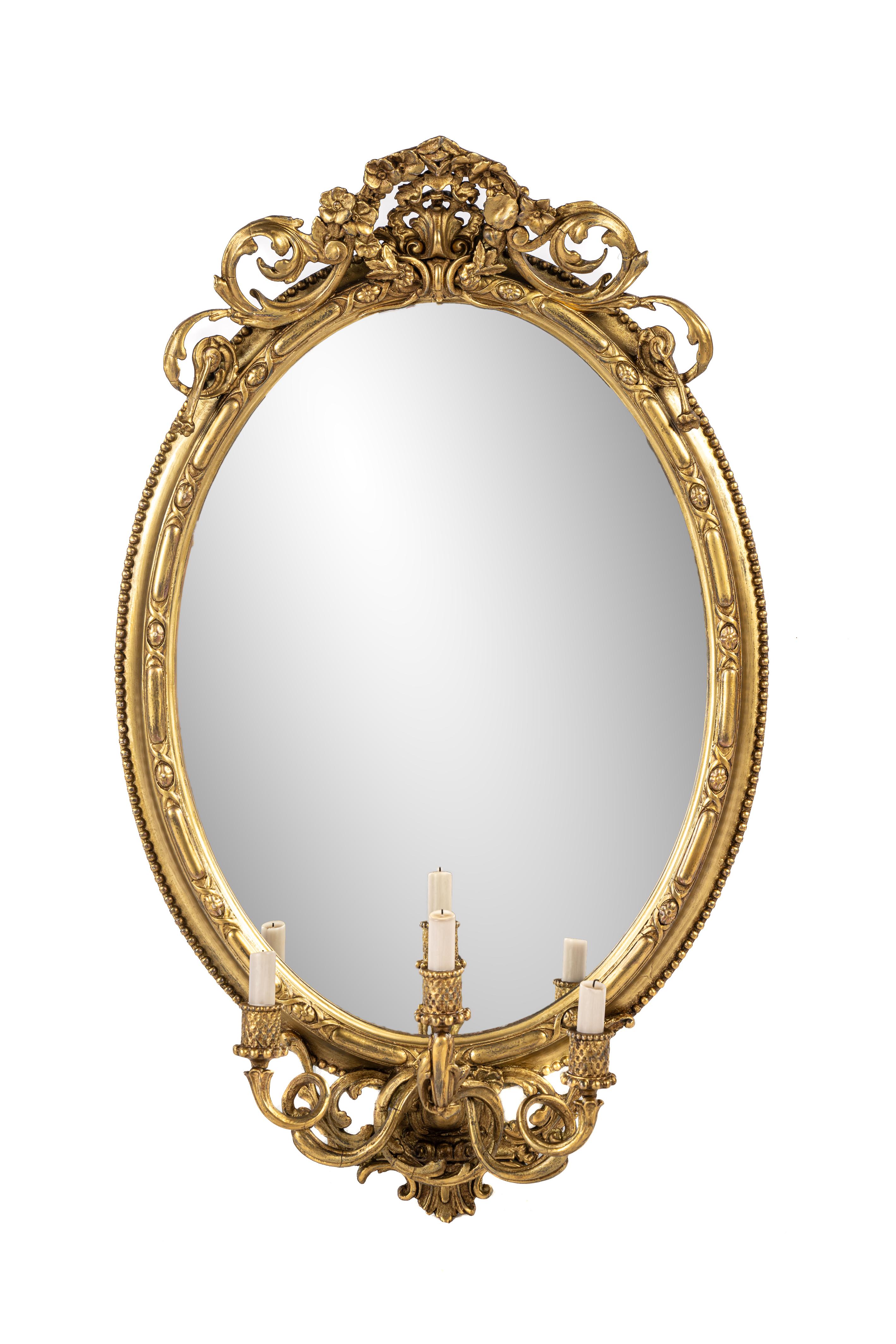 
This stunning antique oval mirror was crafted in southern France during the first half of the 19th century, around 1840. The mirror features an elegant gadrooned pattern on its highest point, and the outer edge is adorned with a classic pearl trim.