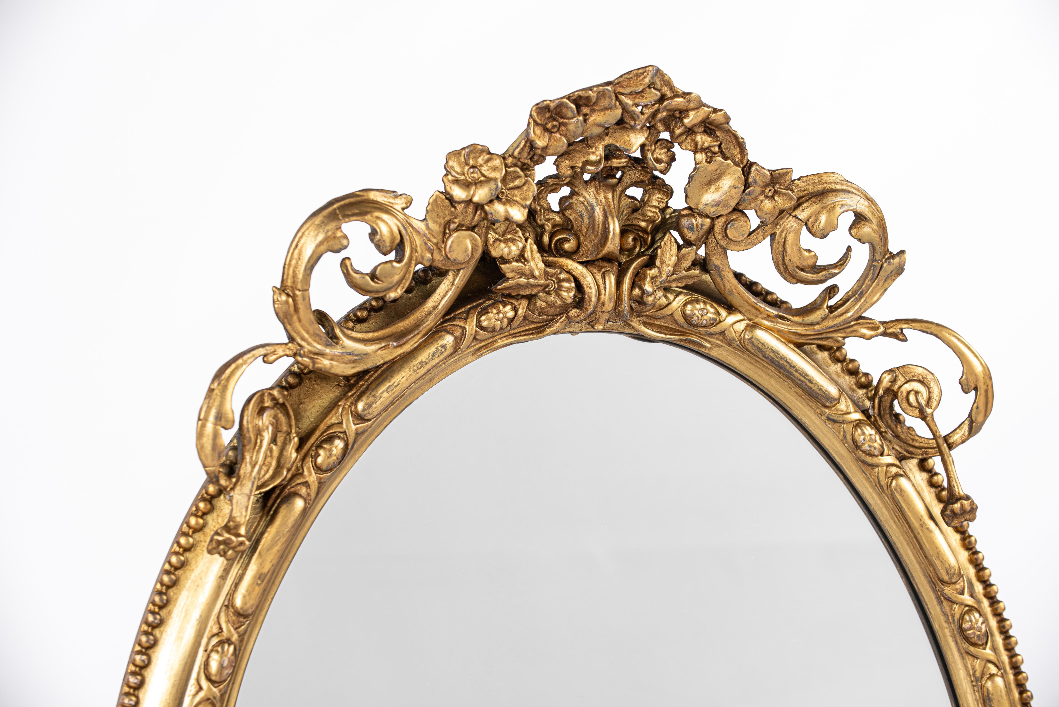 Carved Antique early 19th century French Rococo gold oval mirror with candle holders