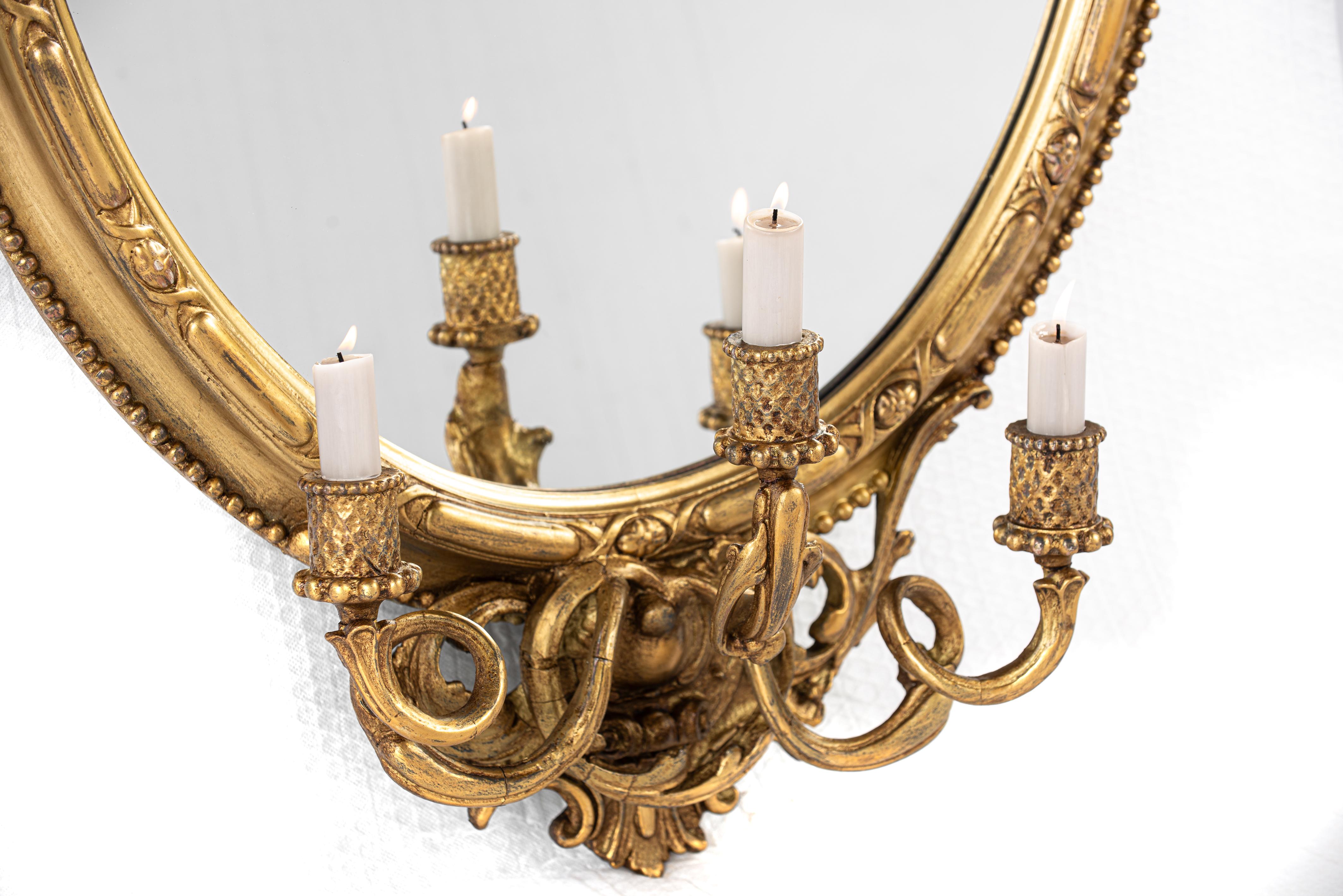 Antique early 19th century French Rococo gold oval mirror with candle holders In Good Condition In Casteren, NL