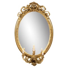 Antique early 19th century French Rococo gold oval mirror with candle holders