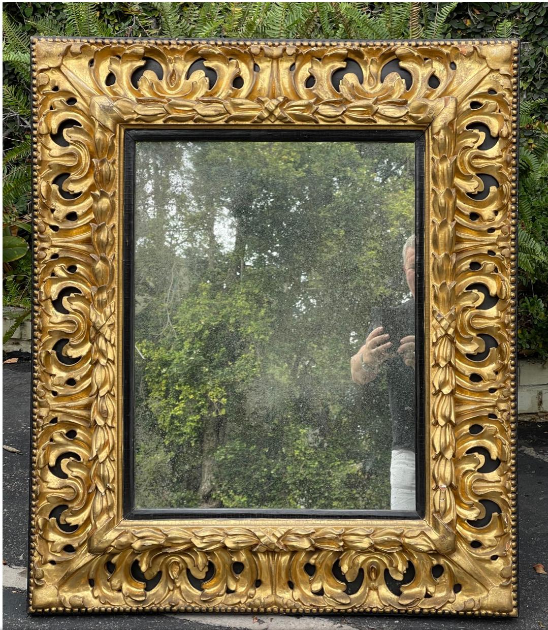 Antique Miroir Empire Louis XVI du début du 19ème siècle en bois doré et ébène. Il présente du bois doré sculpté sur du bois ébénisé et est doté d'un verre miroir vieilli fait sur mesure.