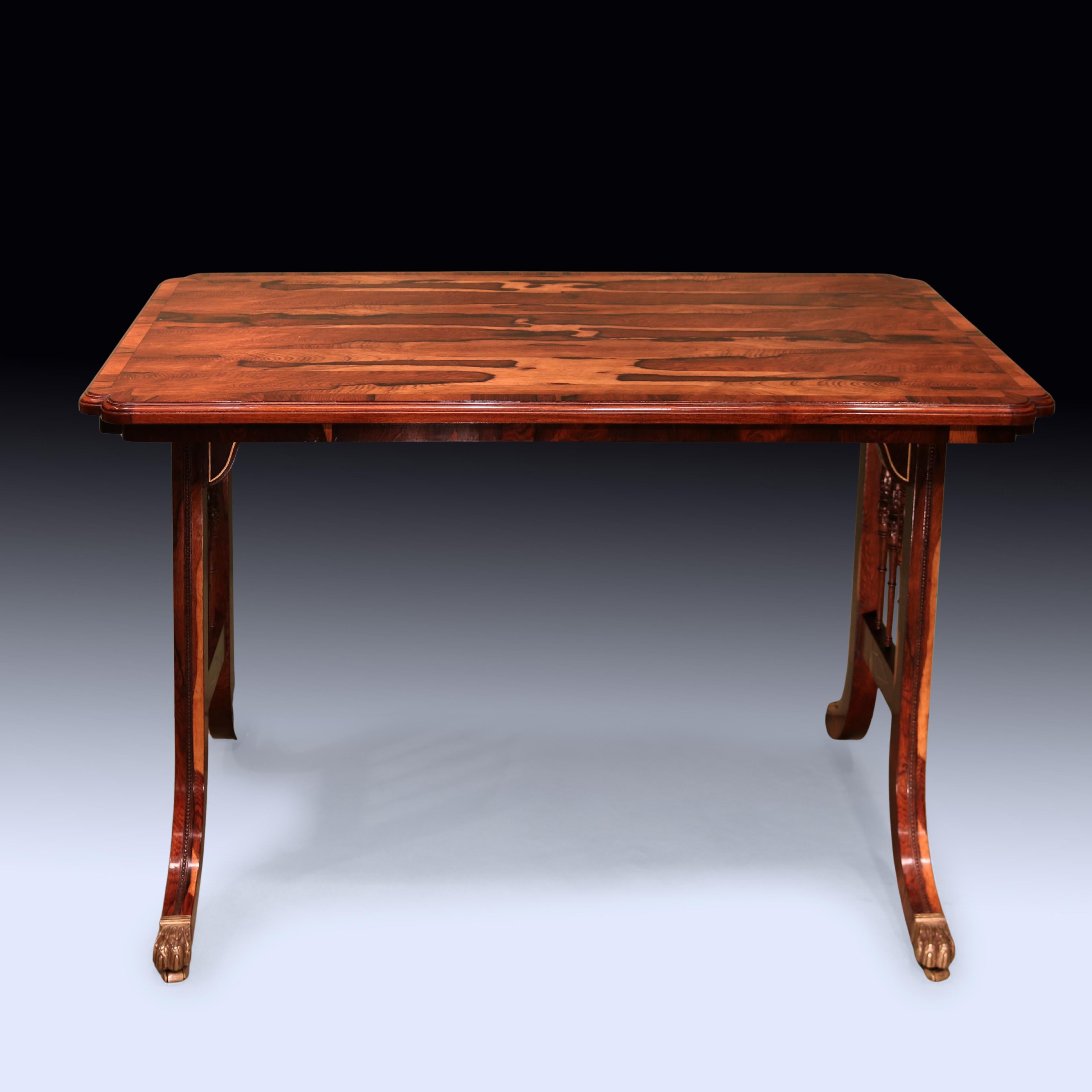 Table à écrire en bois de Coromandel très figuré de la période Regency du début du 19e siècle, avec un plateau à bord mouluré à bandes transversales et coins rentrants, reposant sur des pieds en crosse de hockey perlés et des fuseaux sculptés et