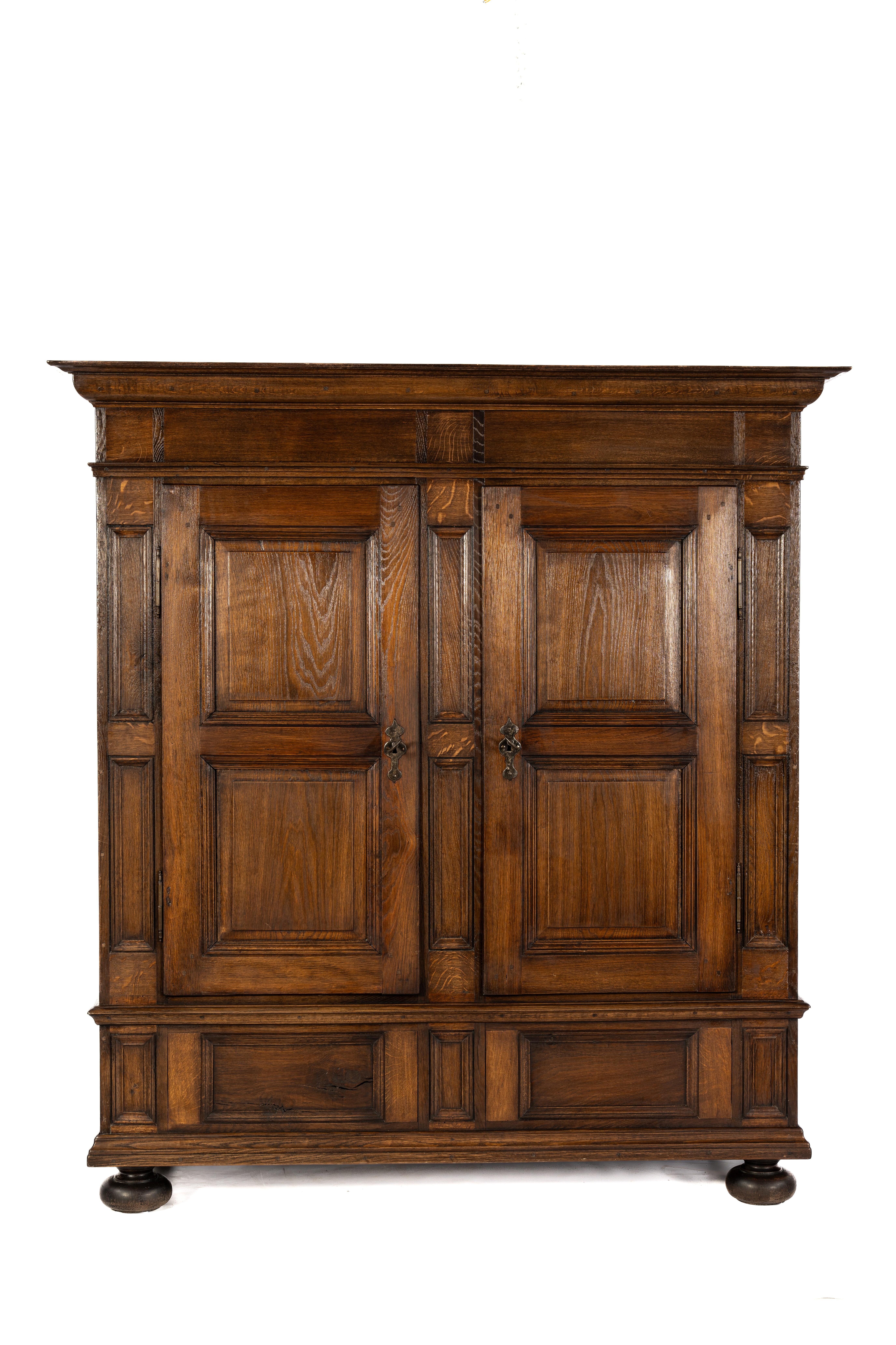 Il s'agit d'une authentique armoire ancienne à deux portes de la région de Westphalie en Allemagne, fabriquée vers 1800. Le meuble est entièrement fabriqué en chêne d'été européen, connu pour son ton chaud et son grain expressif. Les portes