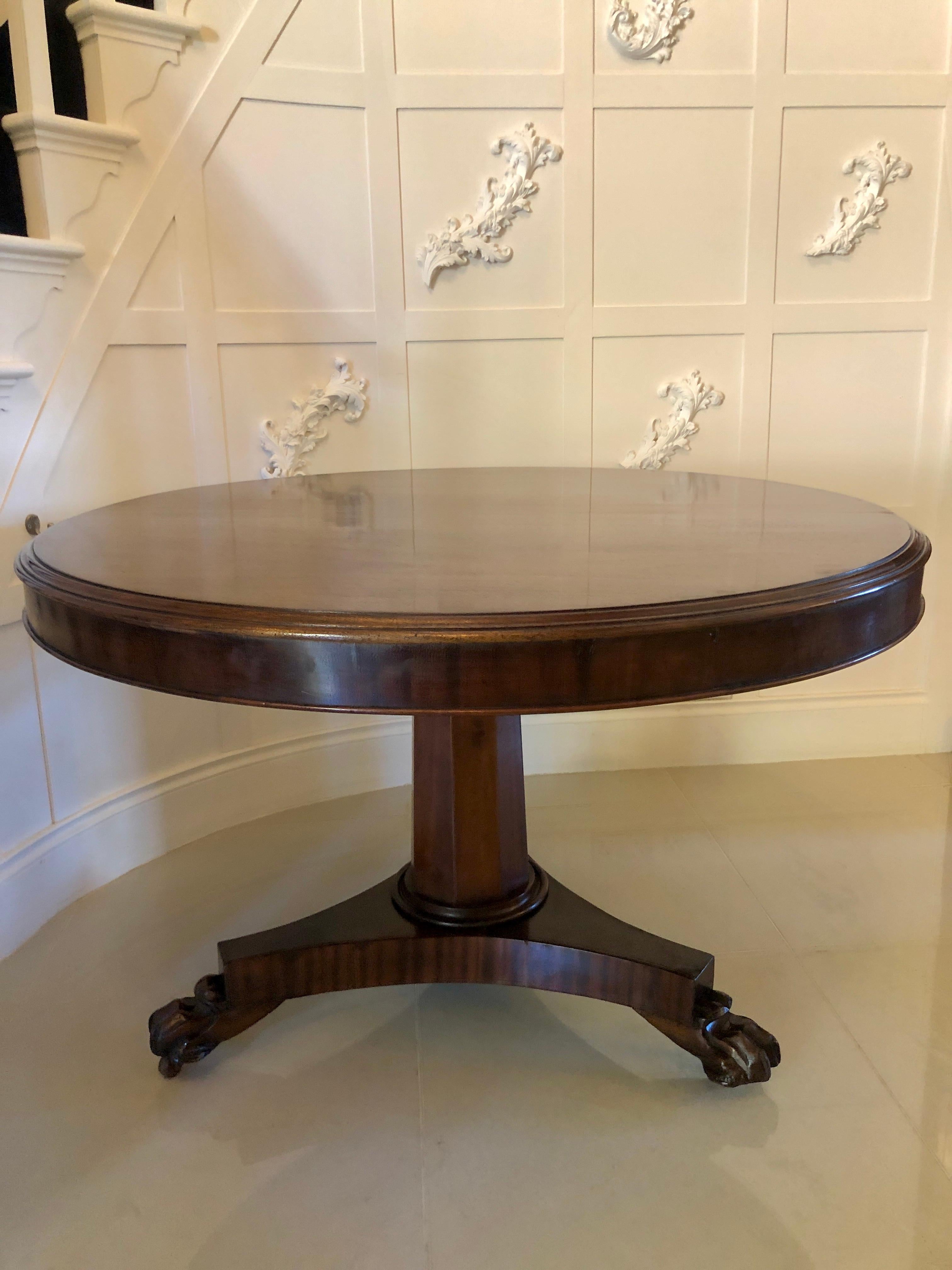 Antique William IV mahogany circular centre table having a quality mahogany top with a thumb moulded edge supported by an attractive octagonal shaped mahogany column. It stands on a shaped mahogany platform base raised by quality carved paw feet on