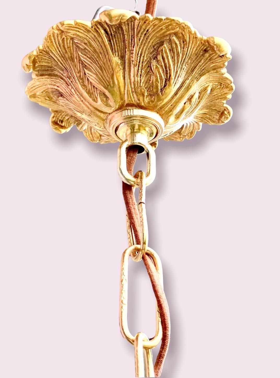 Eine antike fünfeckige Laterne aus vergoldetem Messing und Glas, Anfang des 20. Jahrhunderts, mit einer konischen Form und einem mittleren Arm, der drei Lichter trägt. Die verschnörkelte Kette und der Baldachin aus massivem Messing sind hochwertige