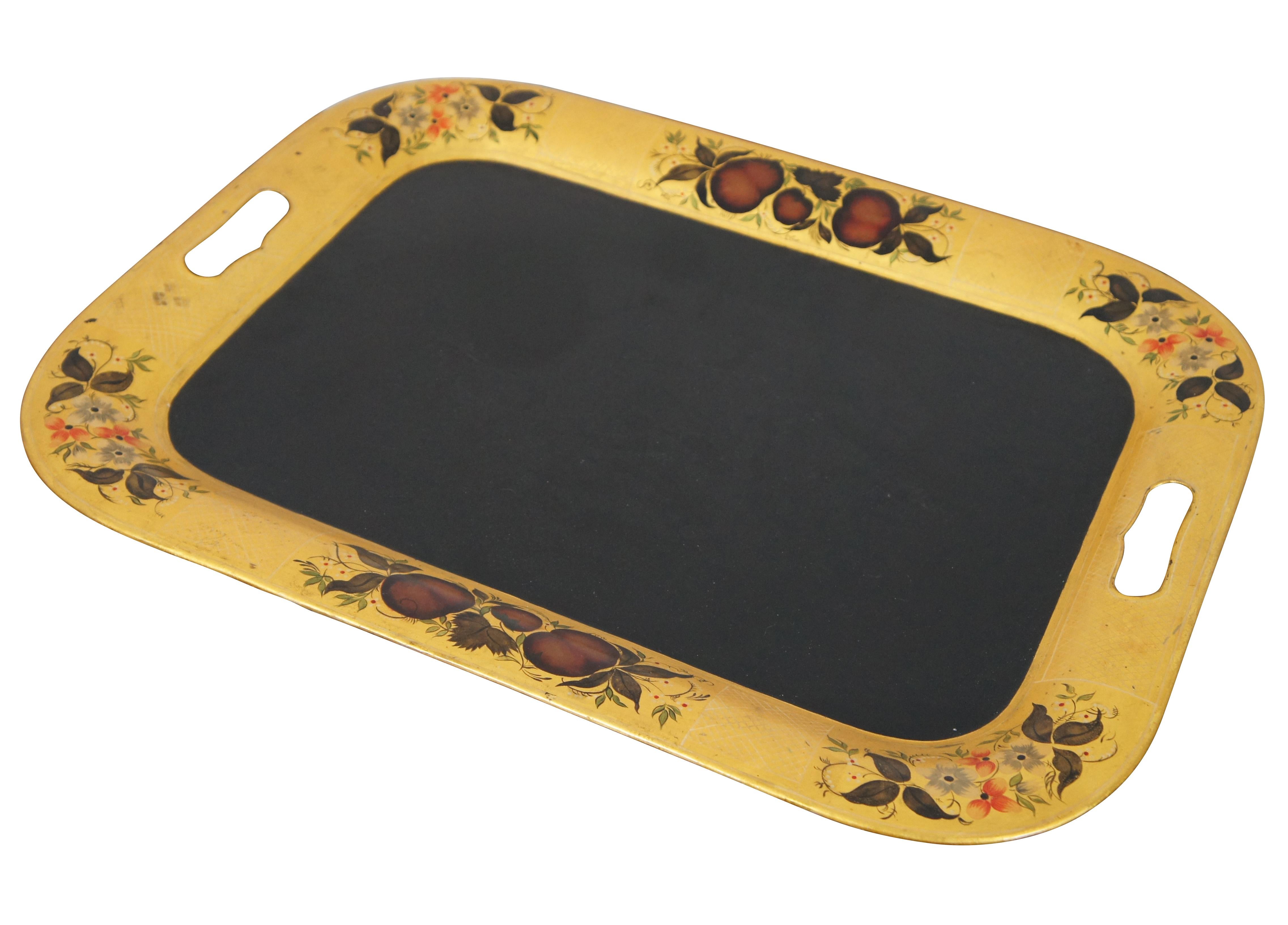 Primitive early 20th century black and yellow toleware tray. Features a handled pattern with stencilled fruit and flower motif.