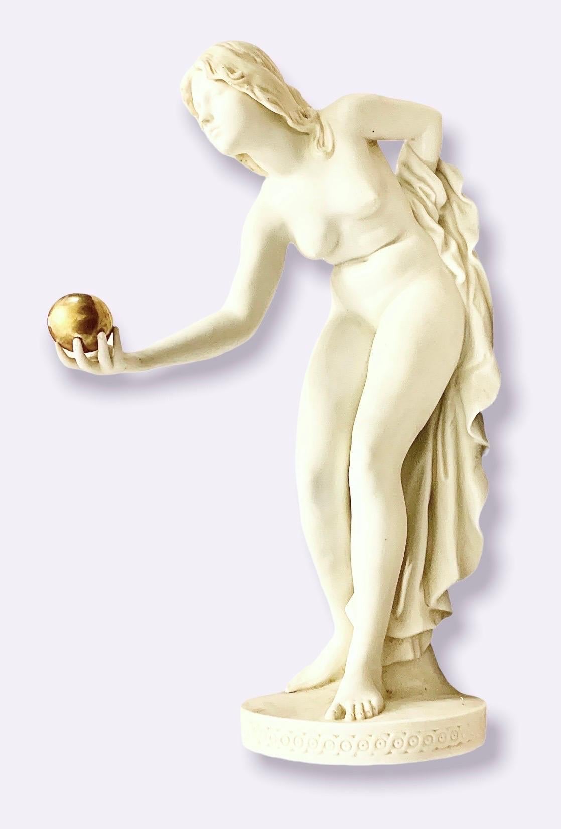 A fine, antique early 20th century Parian polychromed figure of a nude blond woman holding a gilt ball in her right hand. Fine attention to detail is seen in her delicately rendered fingers, feet and face. 
Parian is a fine unglazed biscuit