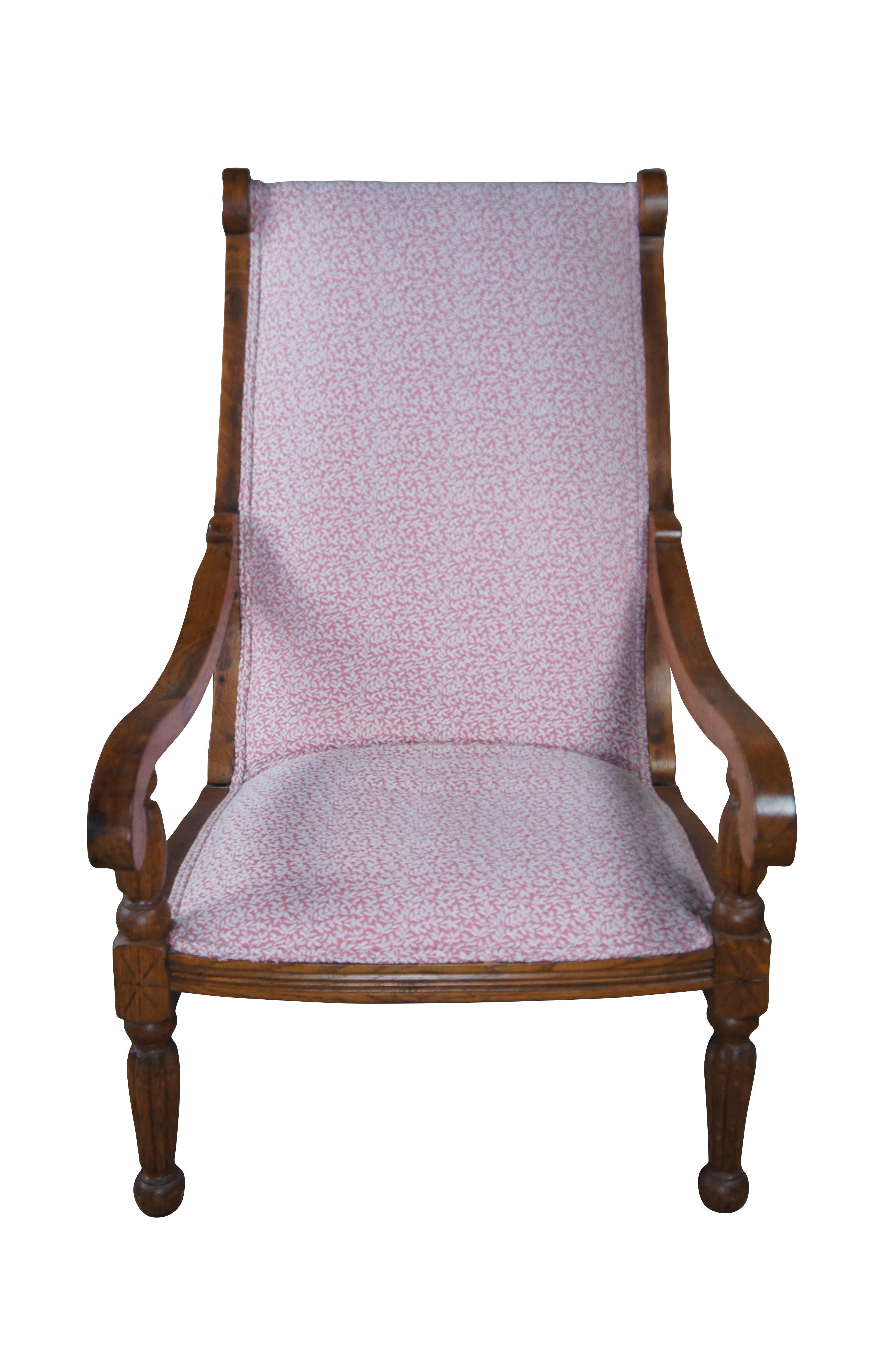 Intrigante chaise de plantation de style colonial britannique du début du 20e siècle.  La structure en chêne présente un dossier traditionnel, des accoudoirs à volutes descendantes sur des supports à balustres cannelés qui se prolongent par des