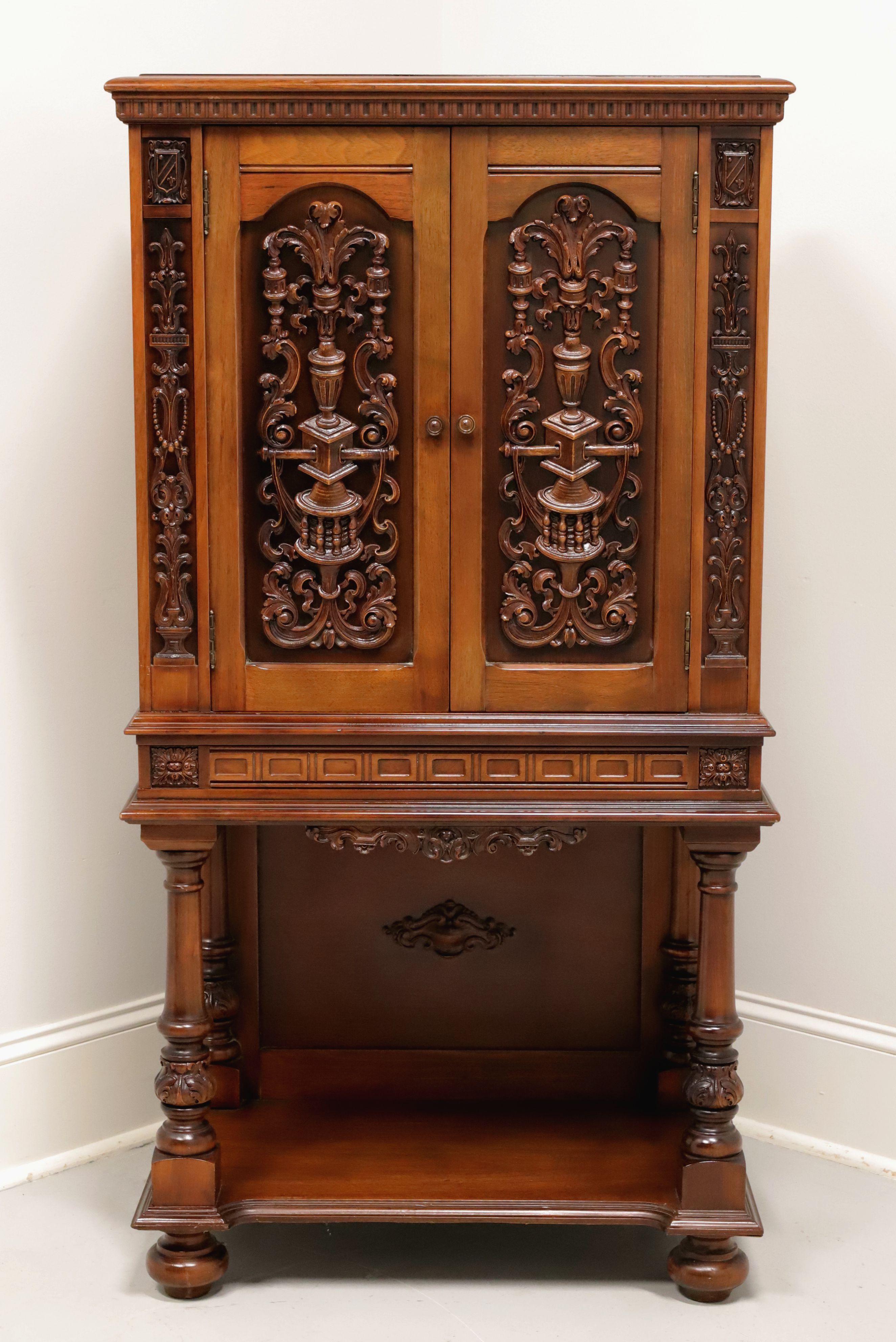 An antique Jacobean style file organizing cabinet, unbranded. Walnut with bevel edge to the top, decorative cornice, carved doors with wood knobs, decorative center apron with beveled edges, undertier shelf with back panel, decoratively carved