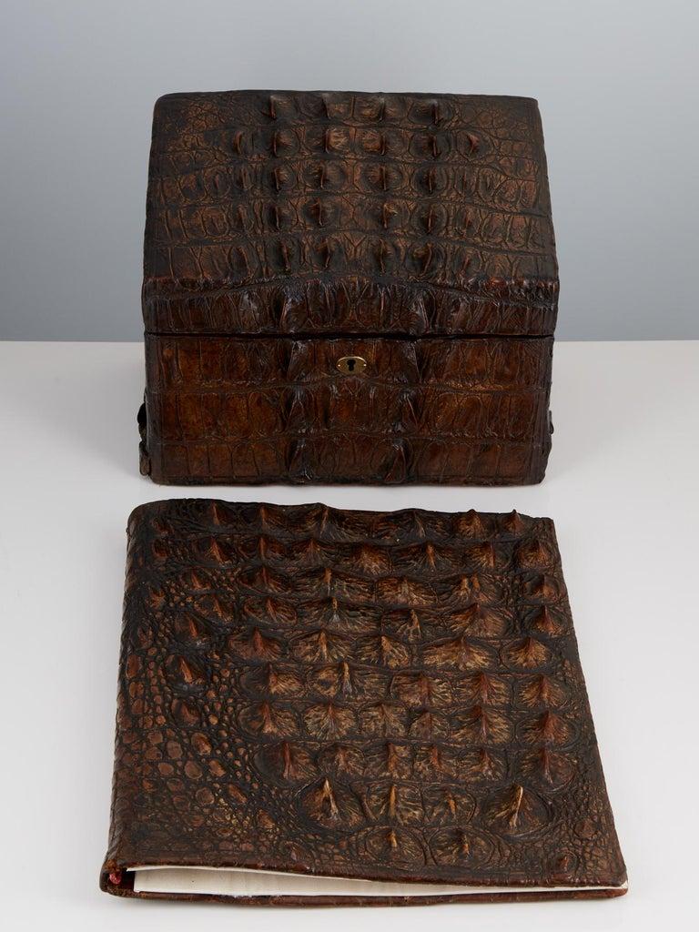 Travel back in time with this impressive antique desk set by Thornhill & Co, London, dating back to circa 1910. 

Crafted with care and wrapped in rugged Nile crocodile skin, this set exudes an air of timeless luxury and sophistication.

The set