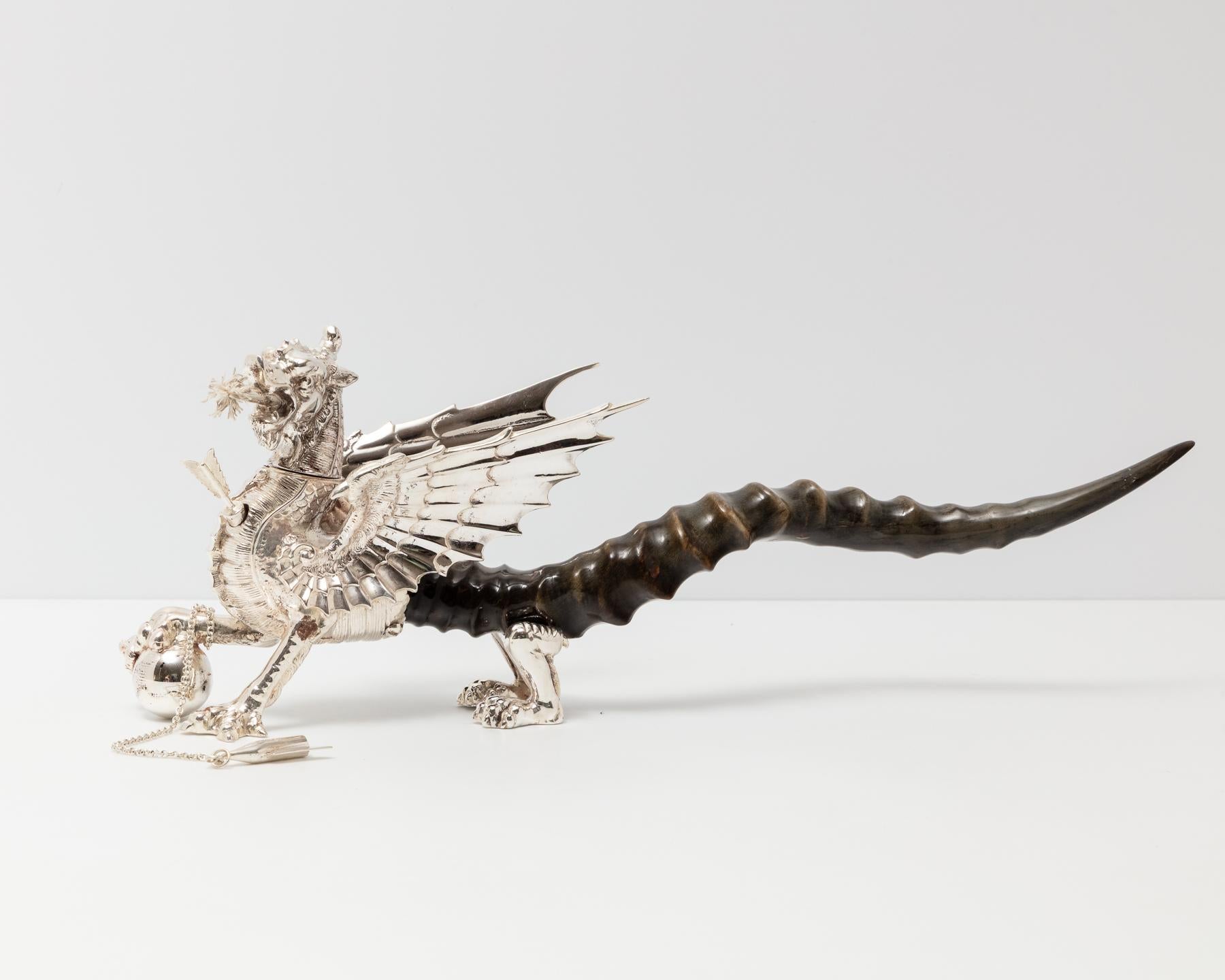 Un raro accendisigari da tavolo dei primi del Novecento a forma di drago, realizzato in Inghilterra nel 1910 circa. Il corpo e la coda sono realizzati in corno di antilope con dettagli argentati, uno stile tipicamente associato alle mense militari