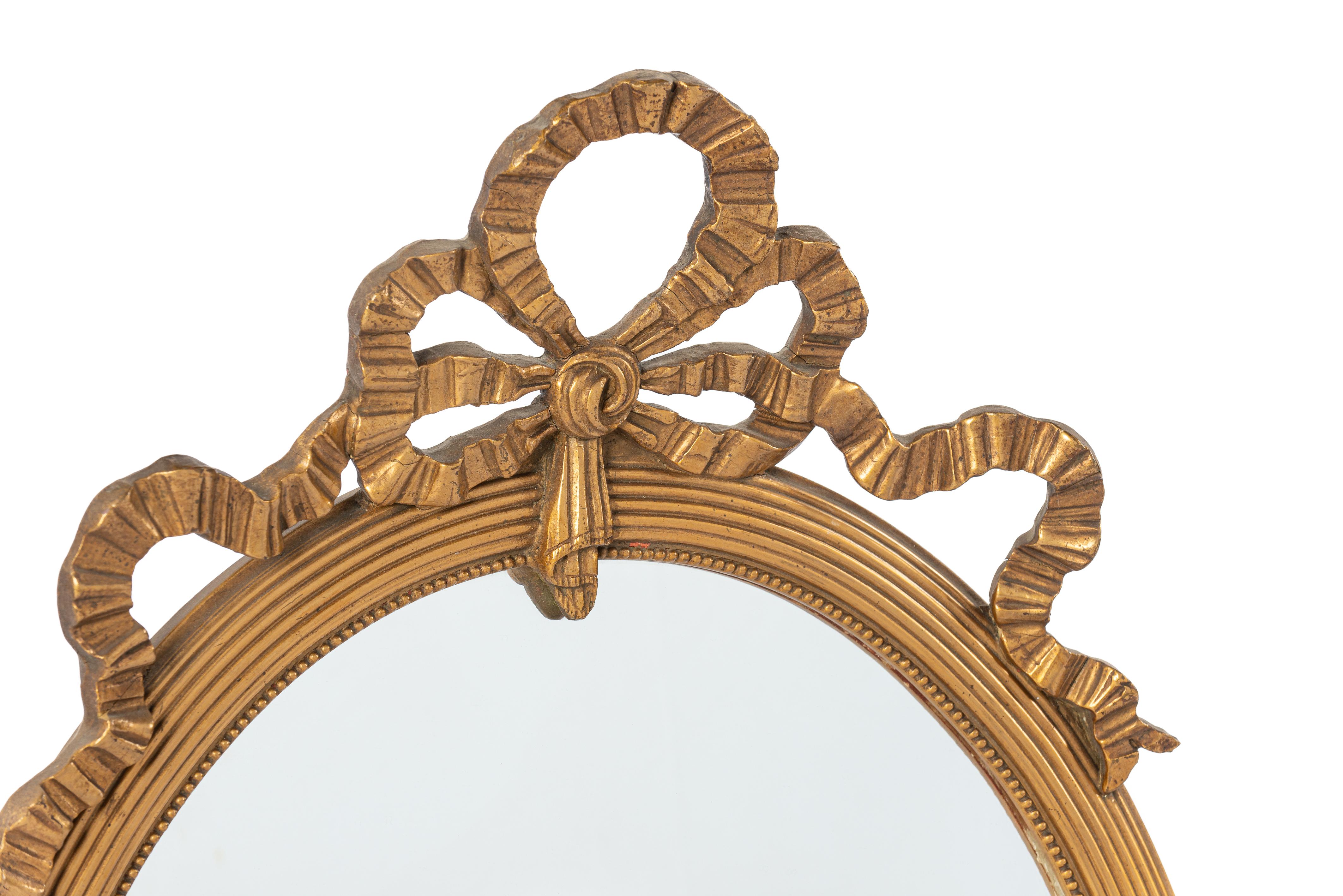 This stunning and elegant oval mirror was crafted in northern France in the early twentieth century, around 1910. The frame is made of linden wood and smoothed with gesso. Adorned with subtle and detailed molding, the frame also features a