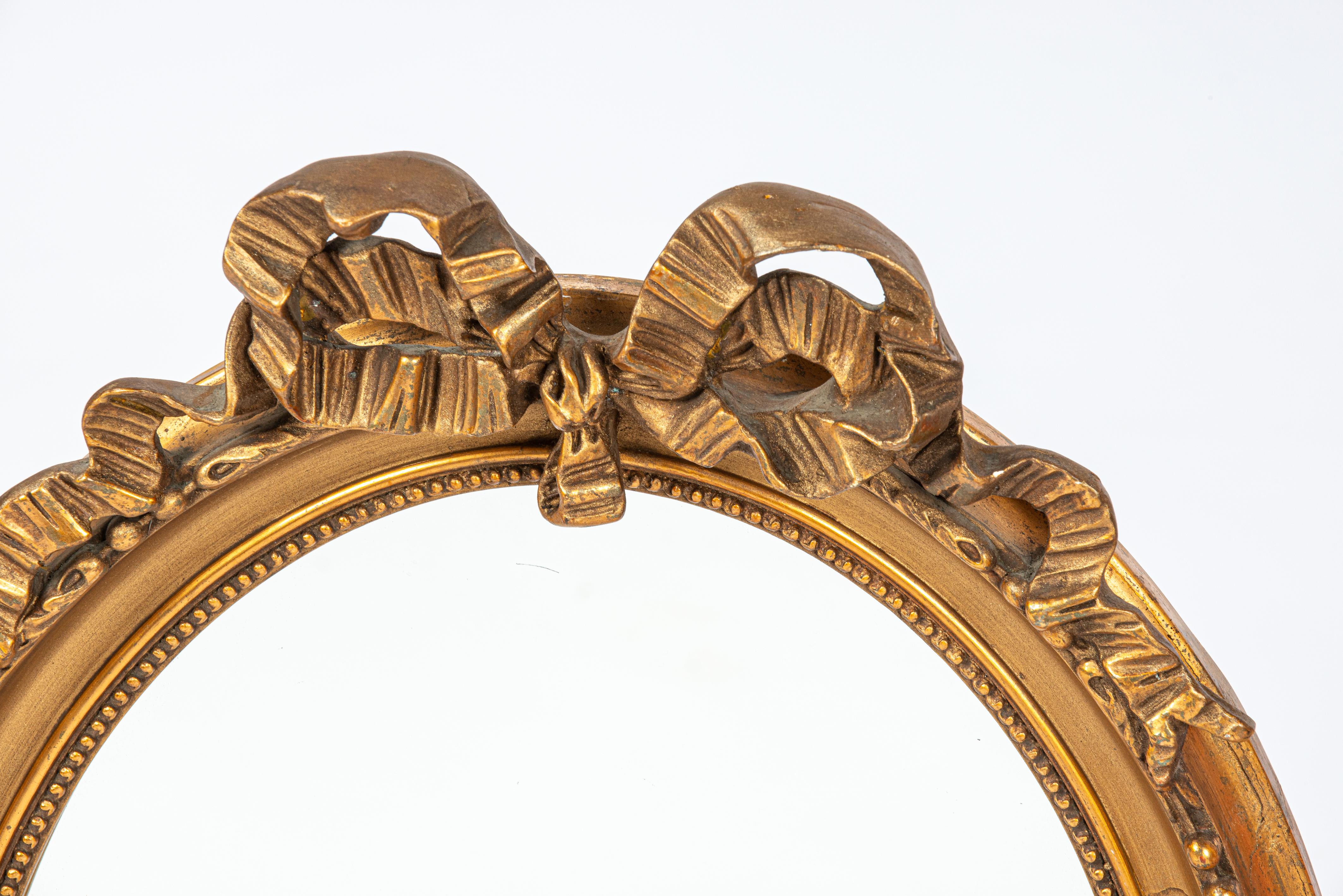 Louis XVI Antique early 20th century French gold gilt oval bow tied ribbon mirror For Sale